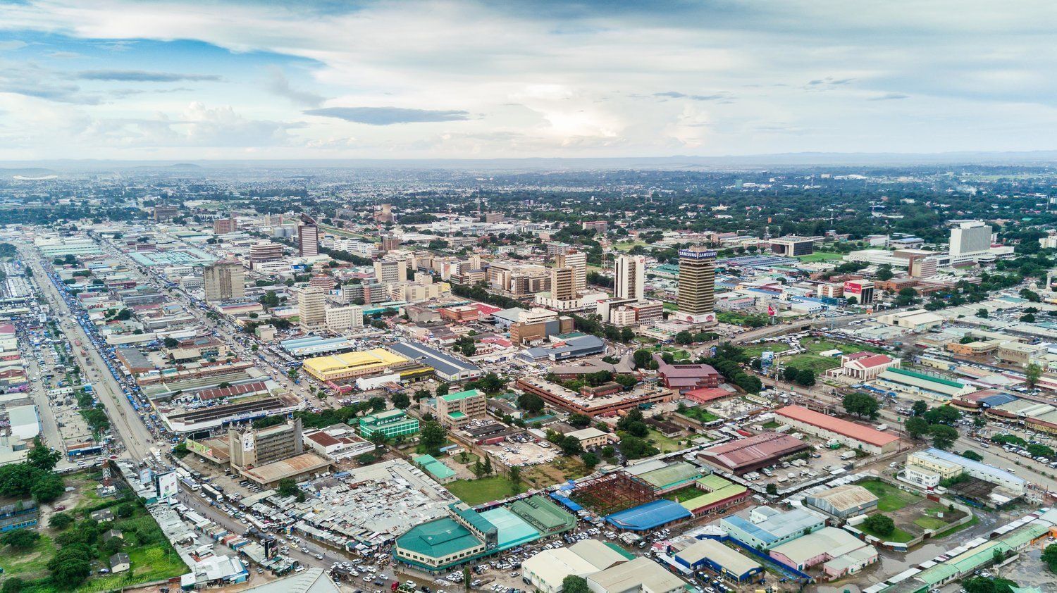 Aerial view of a cityscape in Nigeria with buildings of various heights under a cloudy sky.