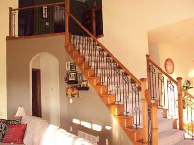 A living room with a stairway in the back