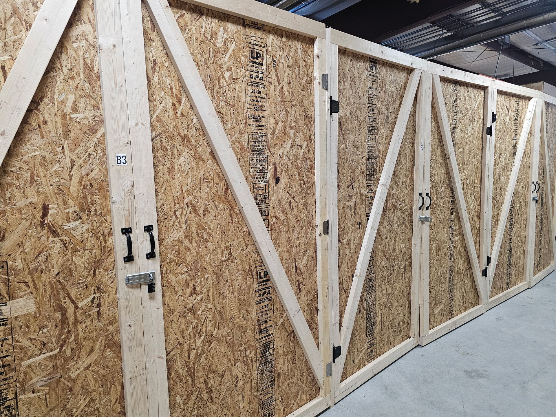 Wooden storage units in a row, each with angled supports and metal latches.