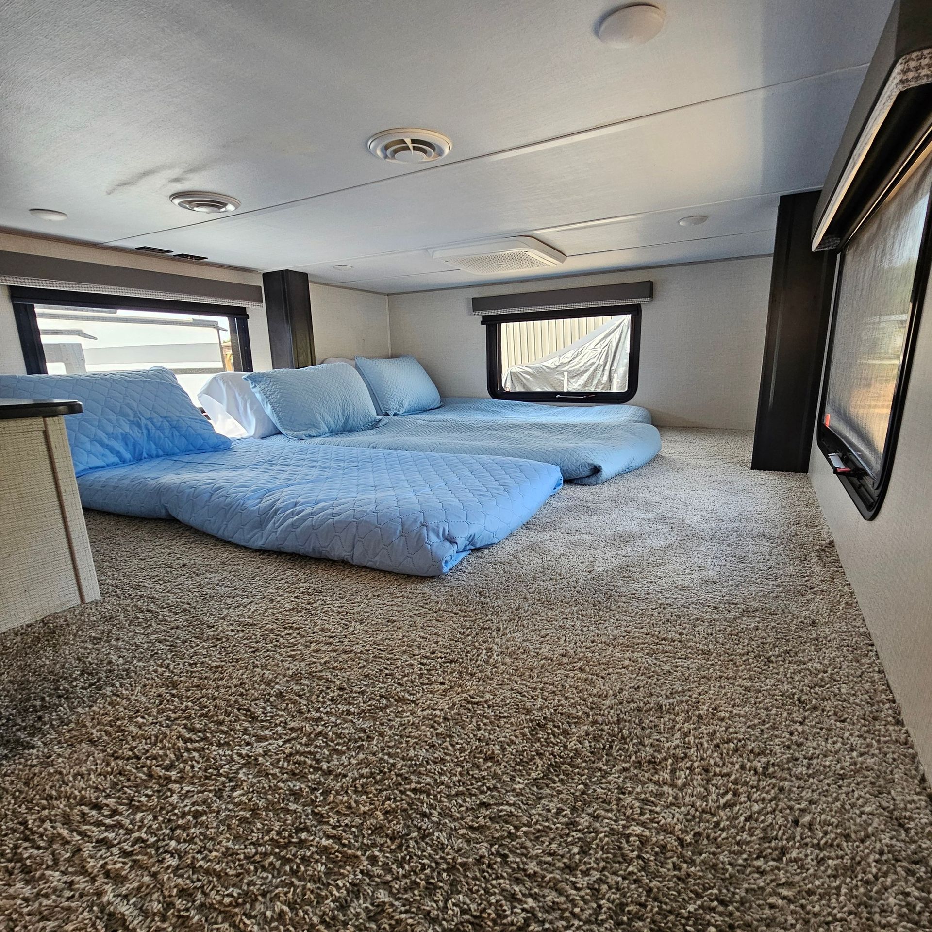 There are two beds in the back of a trailer