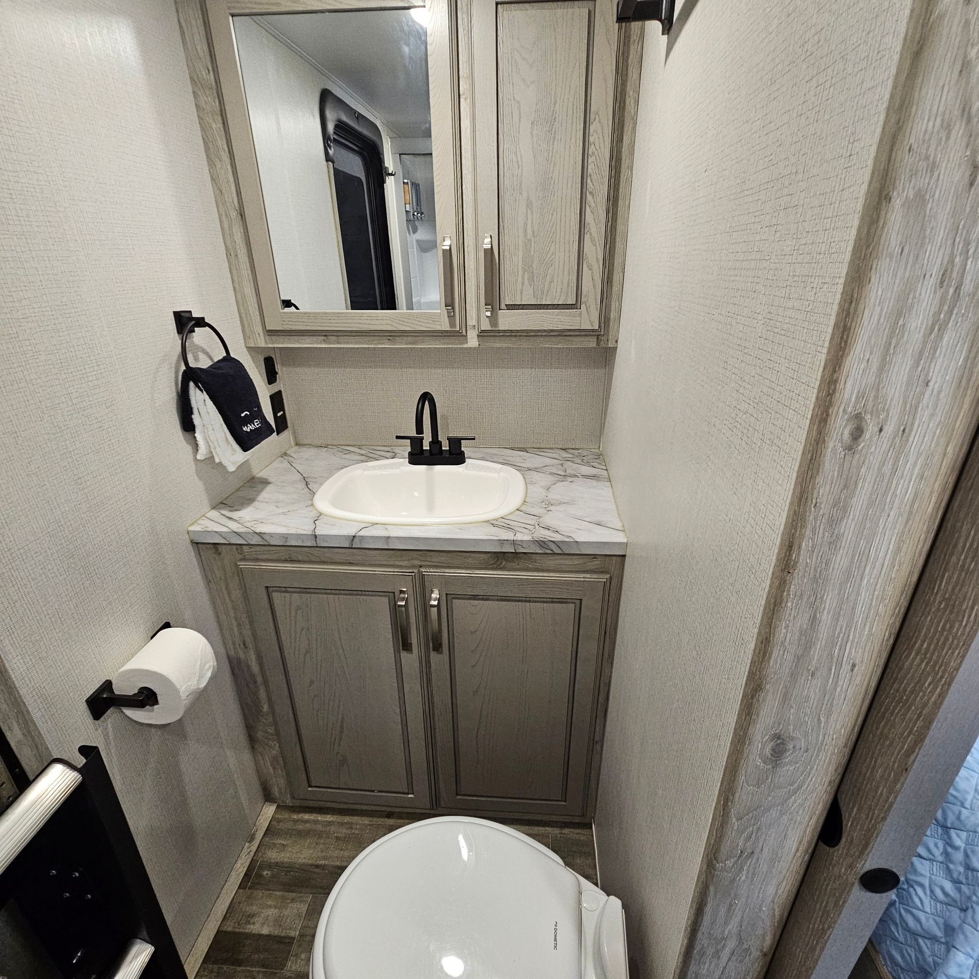A bathroom with a toilet, sink and mirror