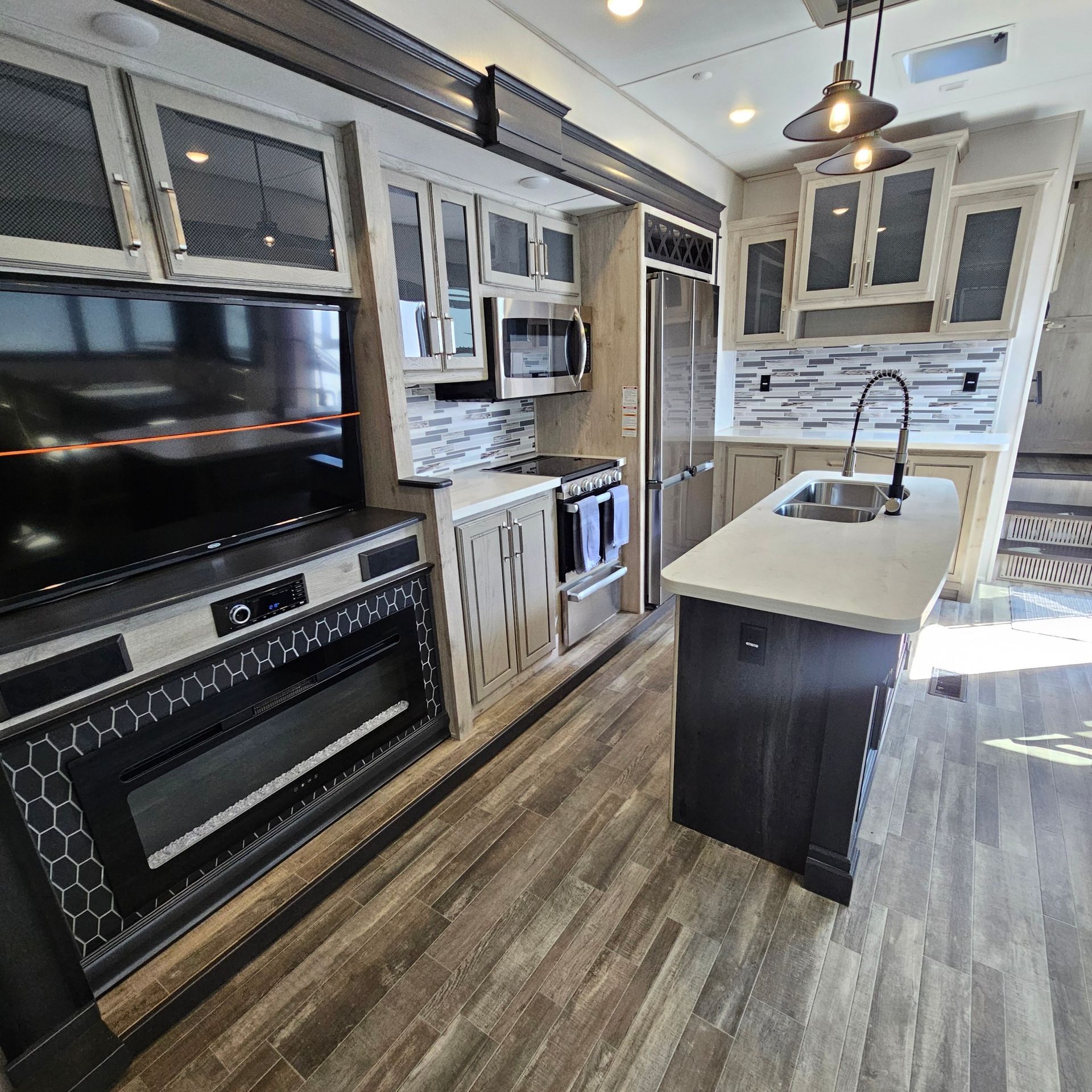 A kitchen with stainless steel appliances and a flat screen tv
