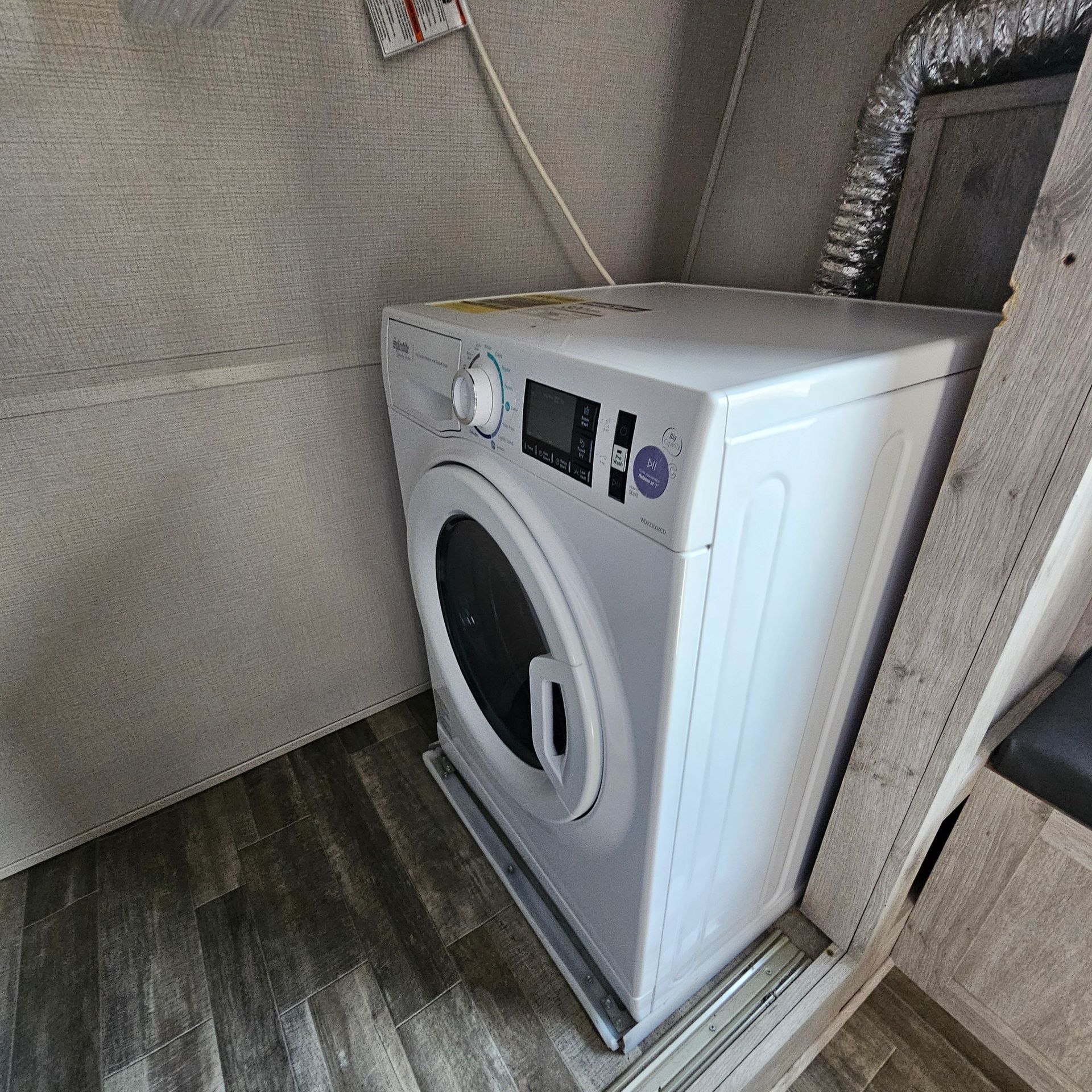 A white washing machine and dryer are in a laundry room
