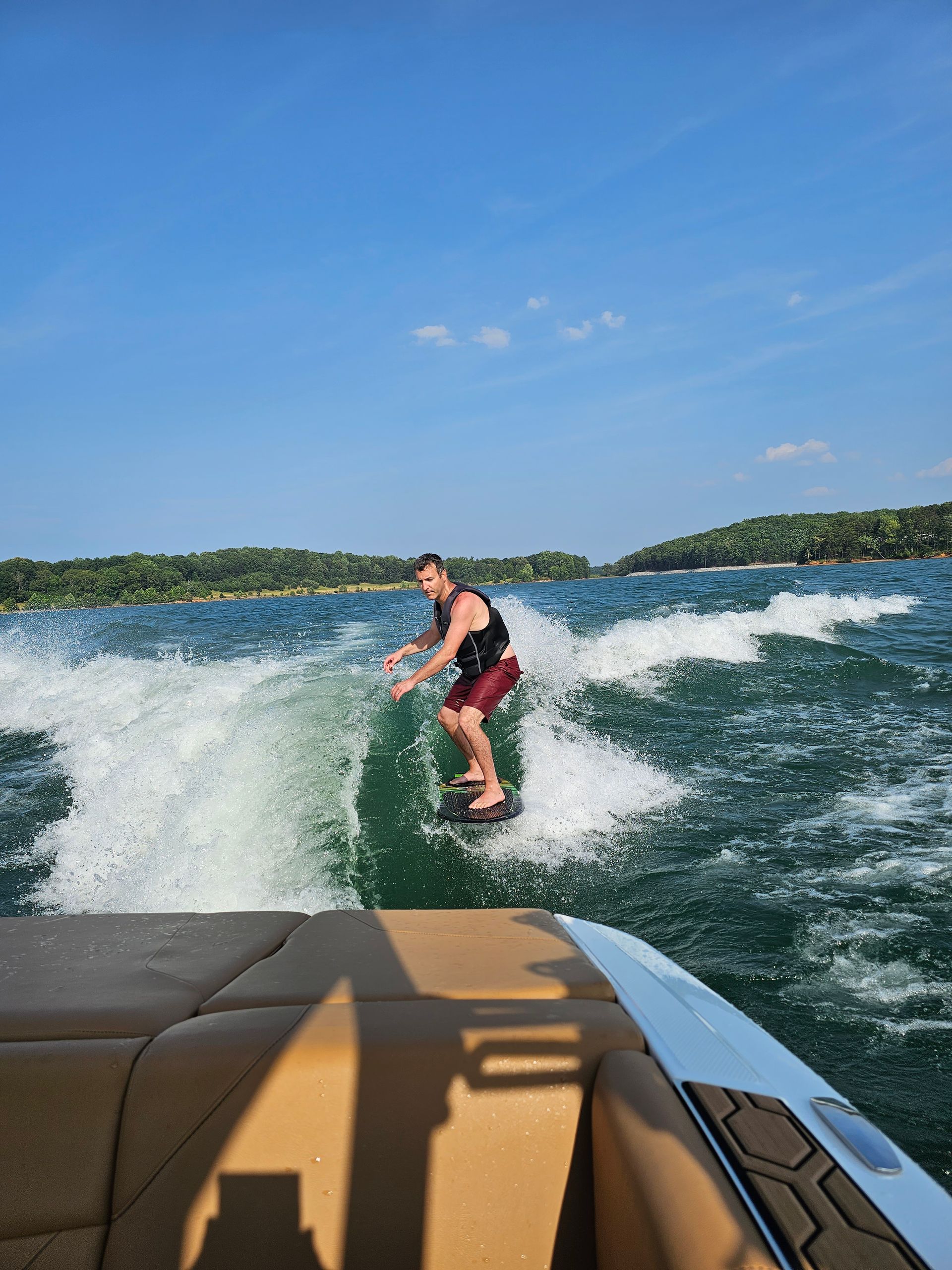 A man is riding a wave on a boat in the water.