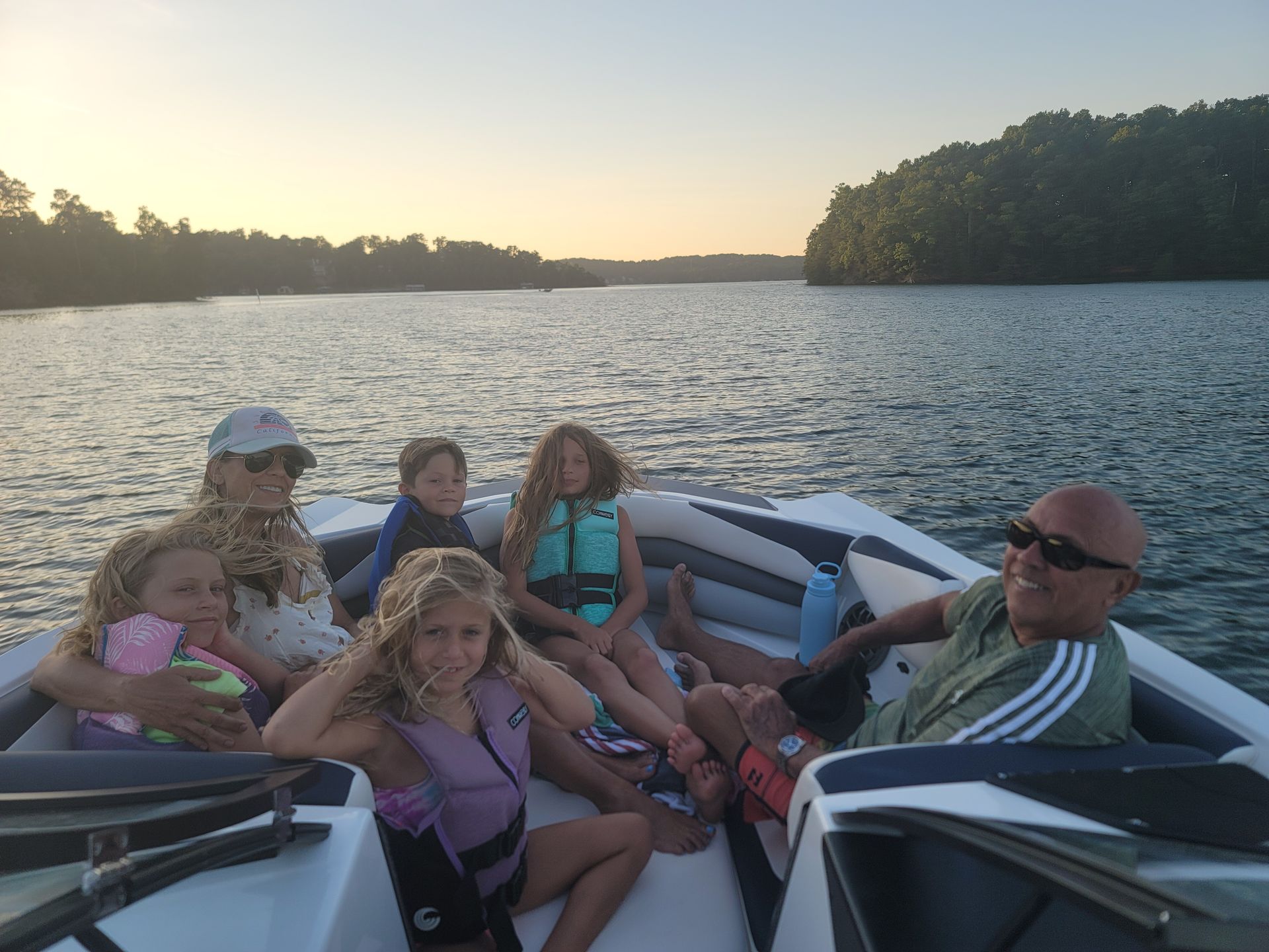 A group of people are sitting on a boat on a lake.