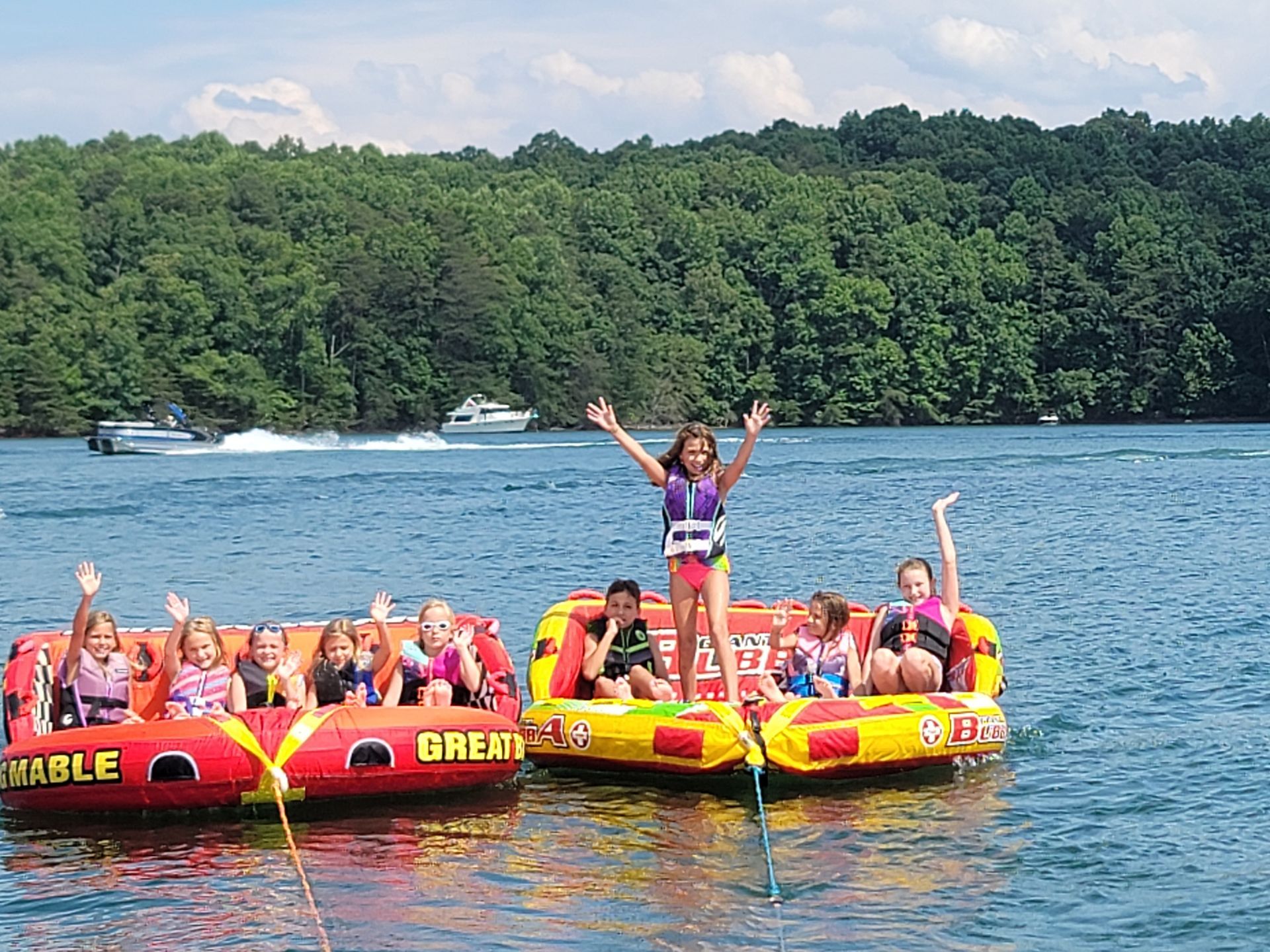 A group of children are riding tubes on a lake.