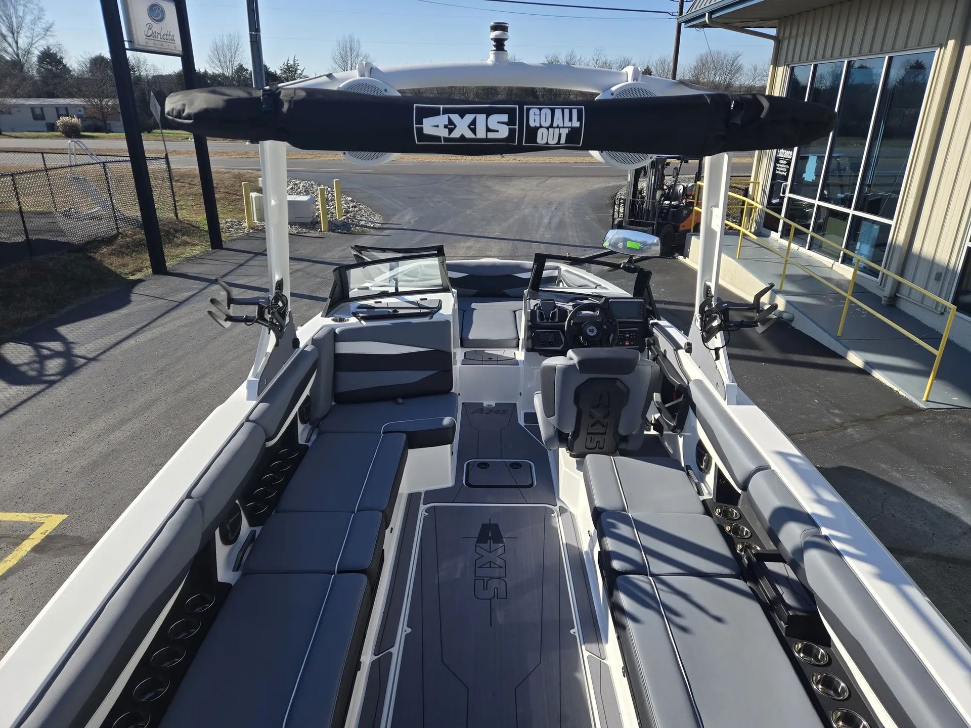 A boat is parked on a trailer in a parking lot.