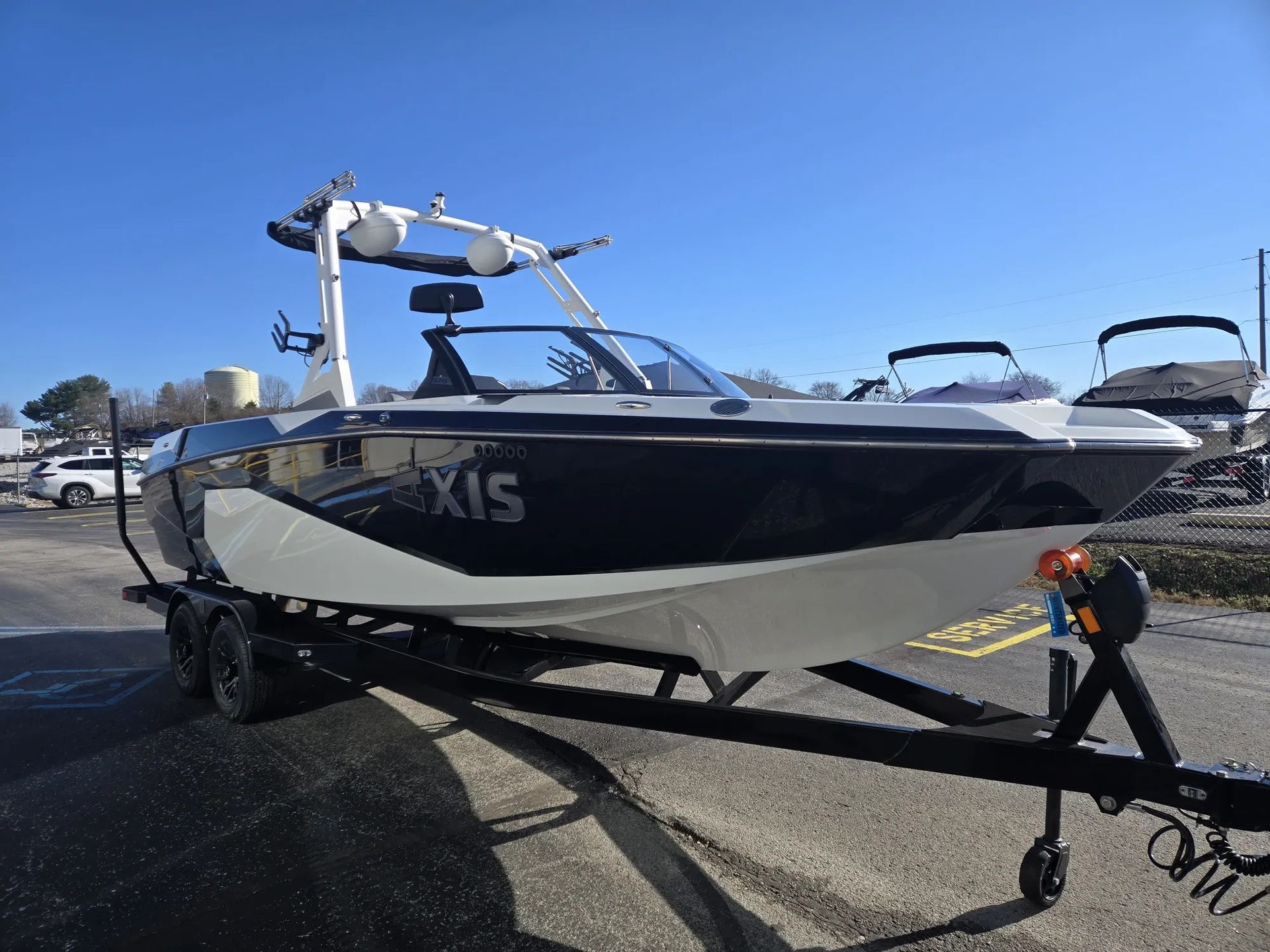 A boat is parked on a trailer in a parking lot.