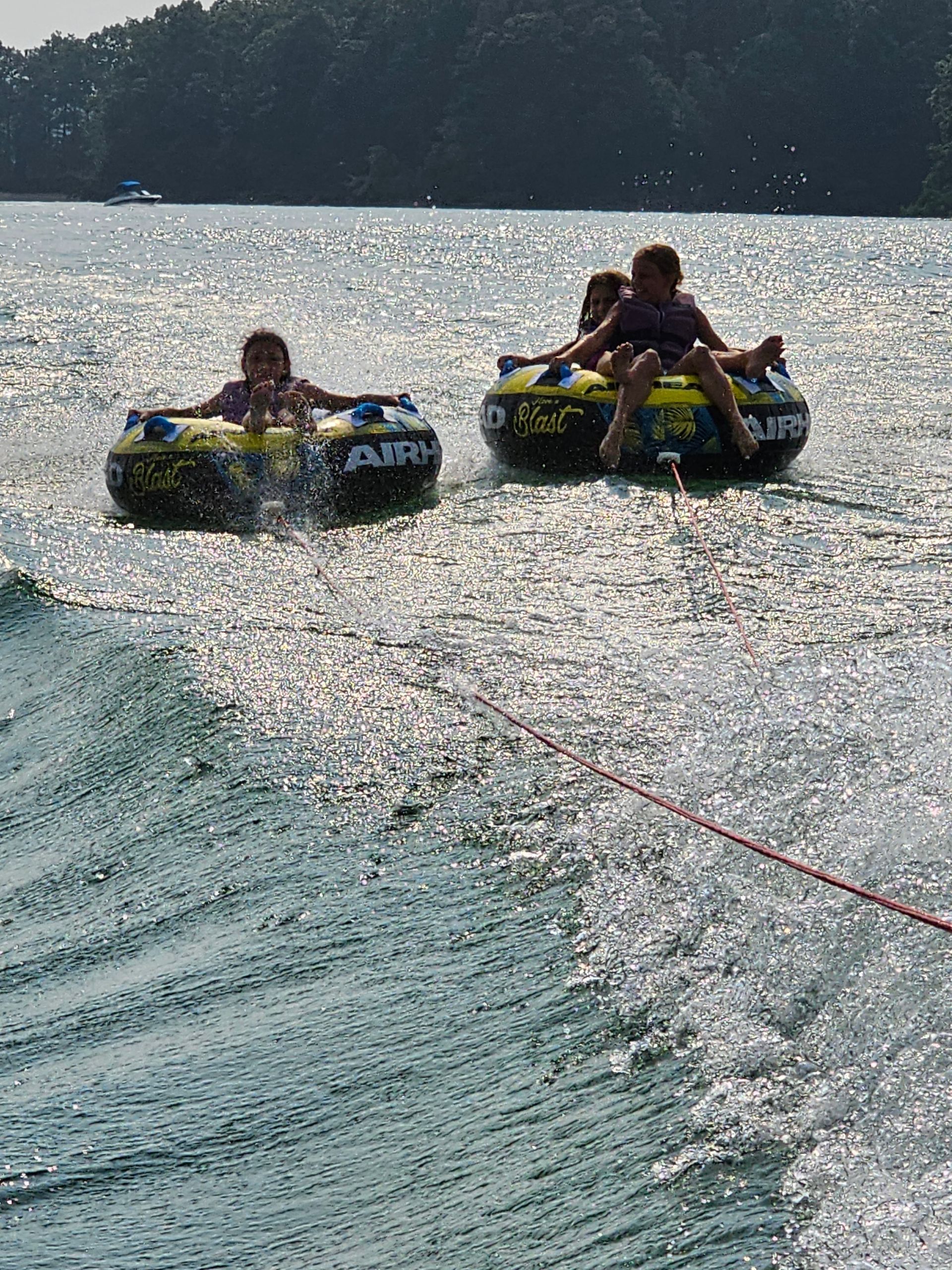 A group of people are riding tubes on a lake.