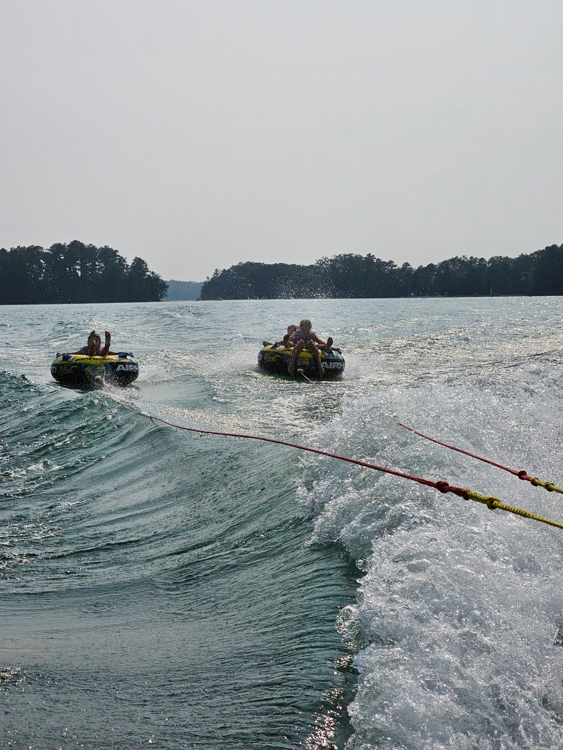 A group of people are riding tubes on a lake.