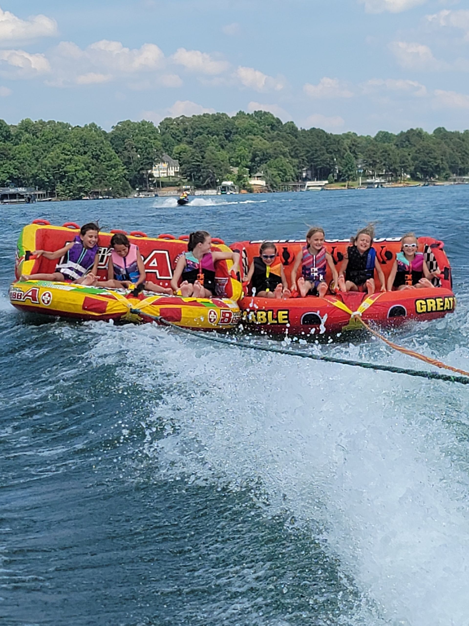 A group of children are riding a raft on a lake.