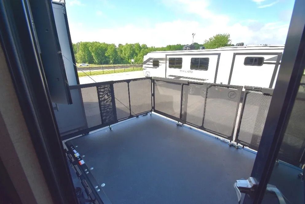 A balcony with a view of a RV parked on the side of the road