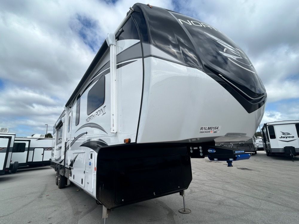 White and black fifth wheel camper with the name 