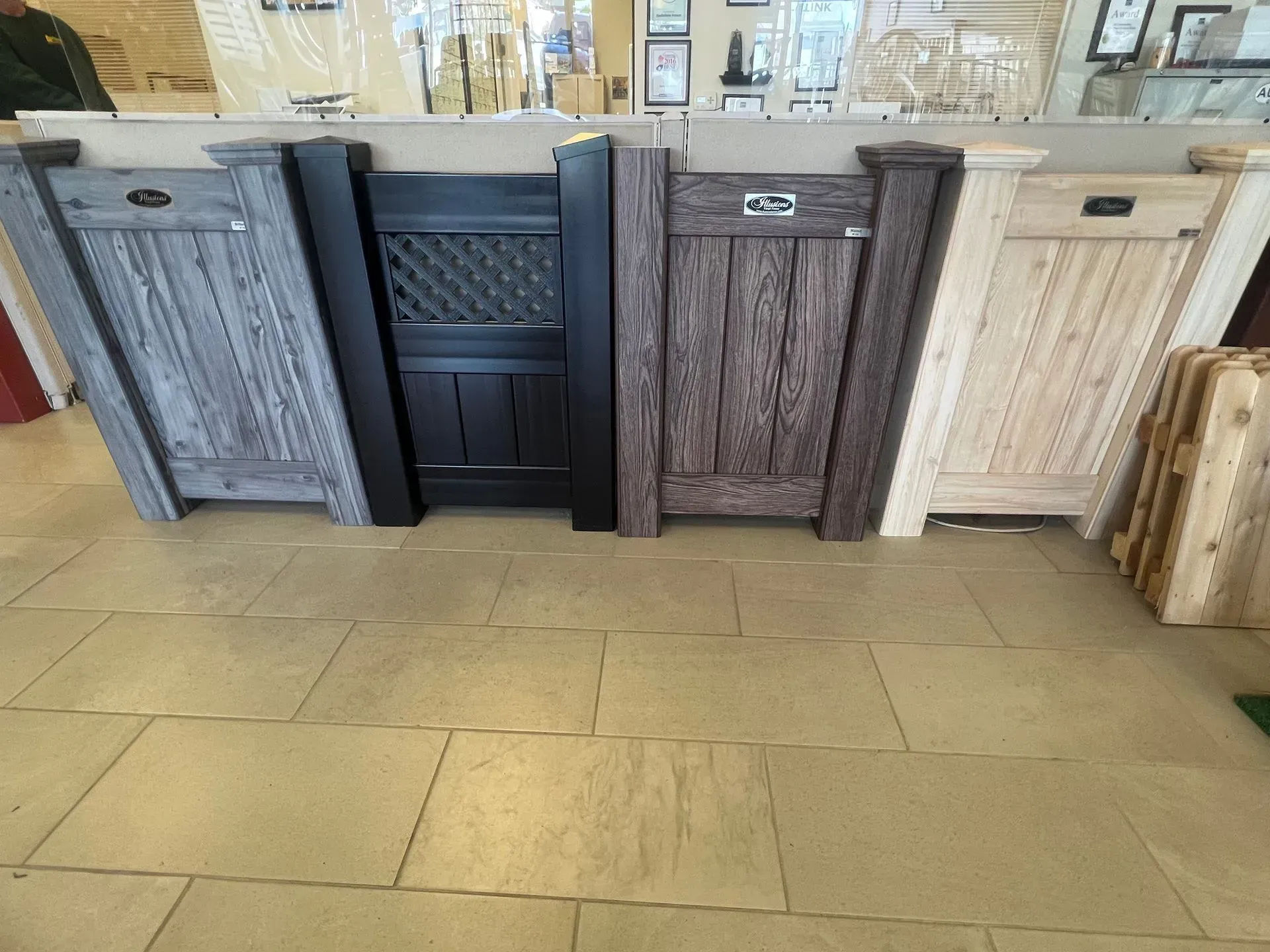 Row of decorative wood cabinets in gray, black, brown, and white on a tiled showroom floor.