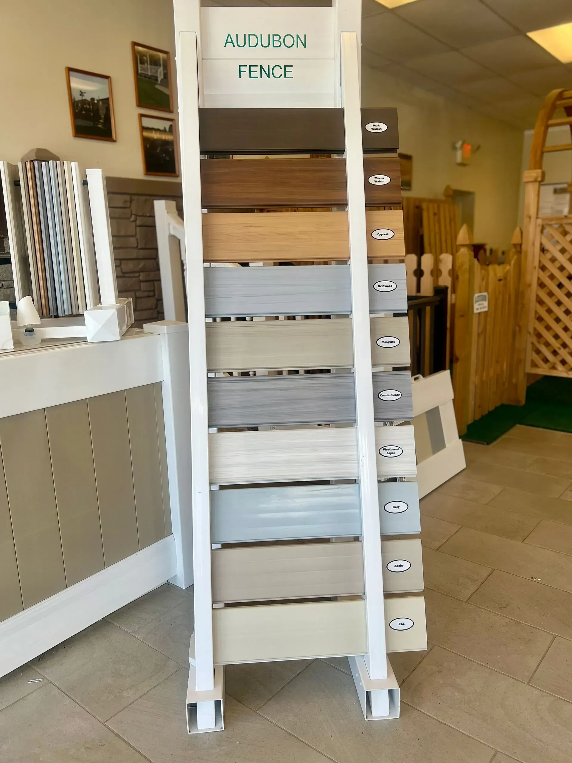 Tall white wooden display rack with stacked folded items in a shop interior.