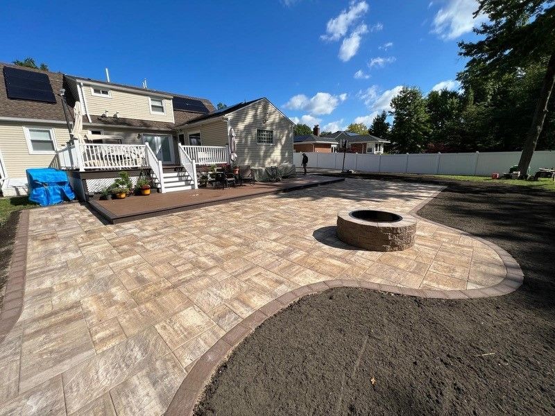 A red truck is parked on the side of the road next to a sidewalk.
