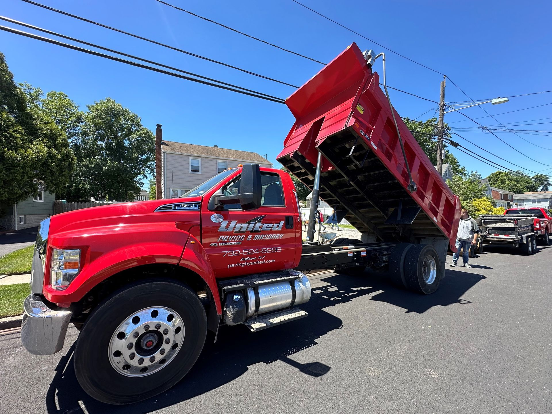 A red dump truck is parked on the side of the road