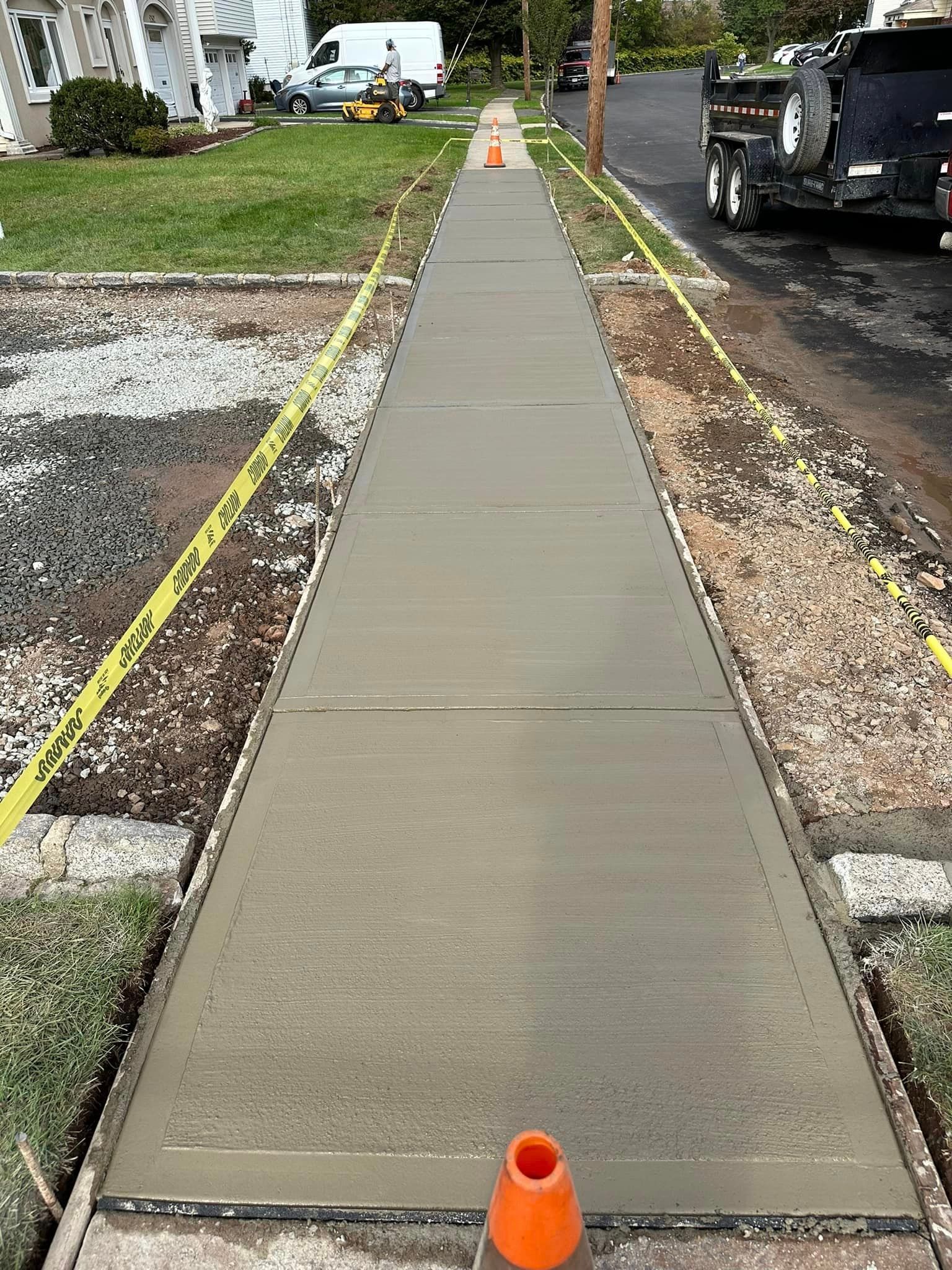 A concrete sidewalk is being built in front of a house.