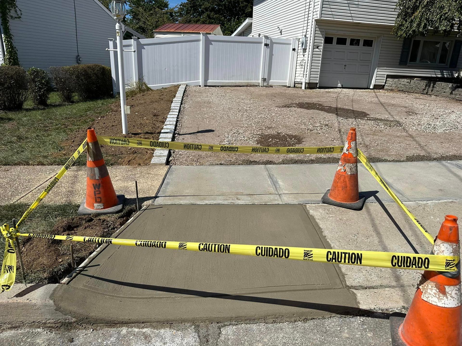 A concrete walkway is being built in front of a house