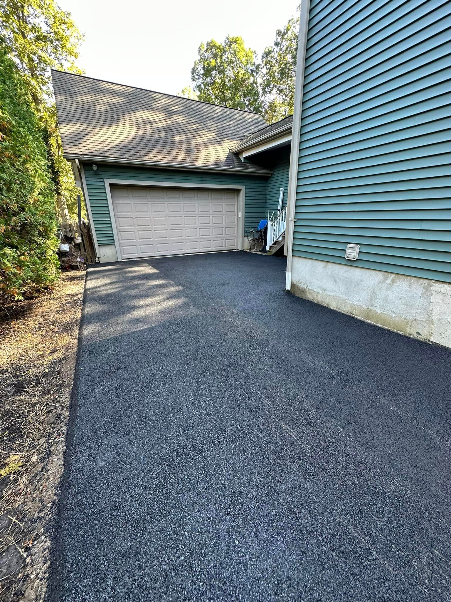 A driveway leading to a garage next to a house.