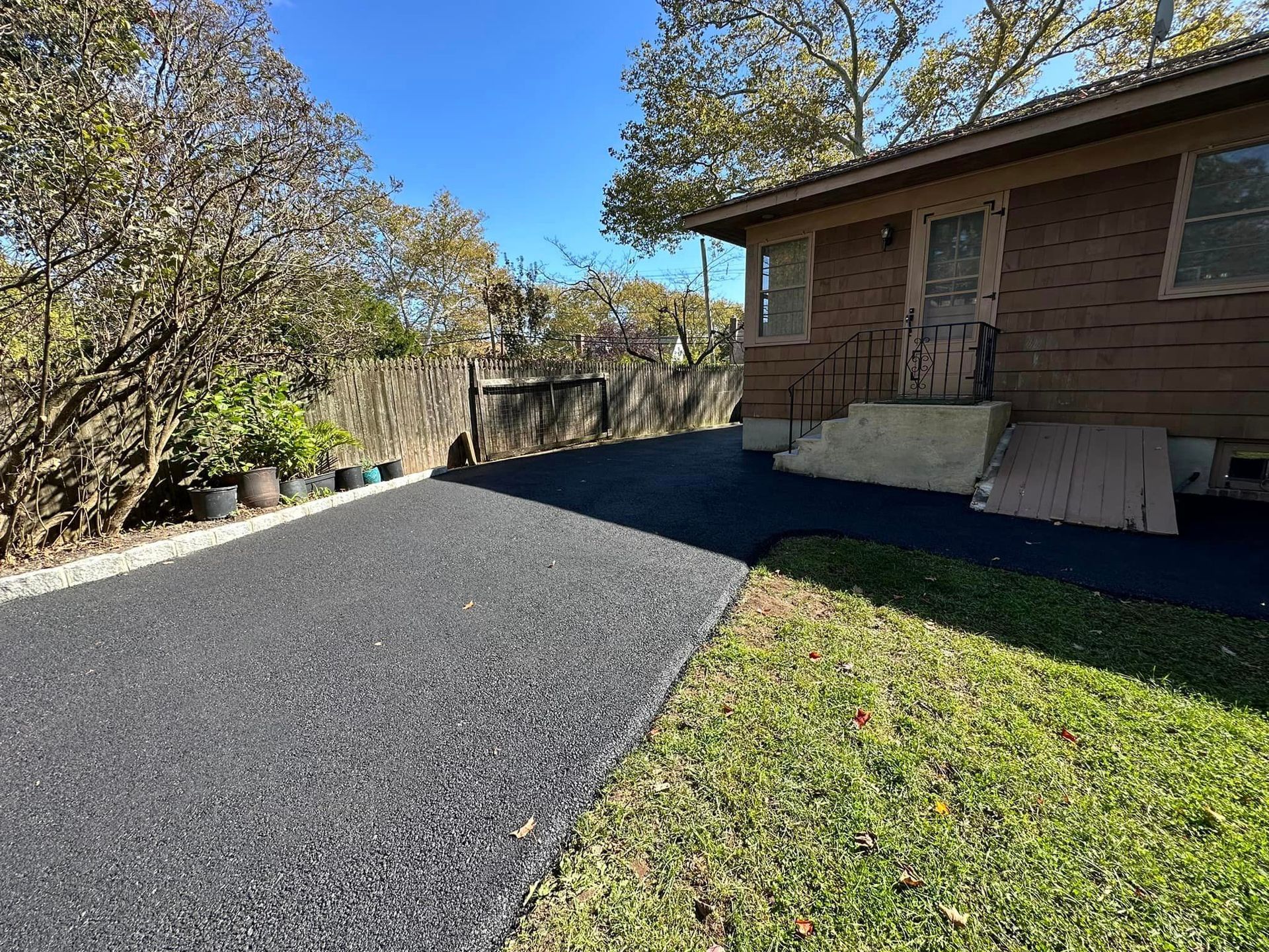 There is a driveway leading to a house with a ramp.