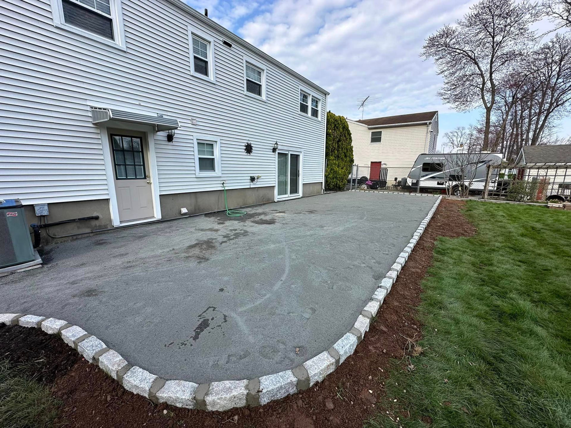 A large white house with a large driveway in front of it.