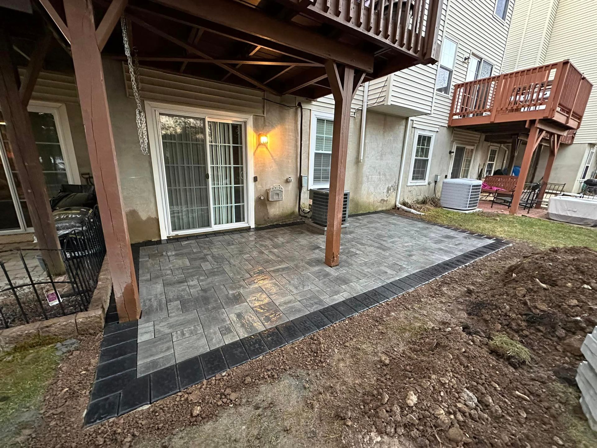 A patio is being built in the backyard of a house.