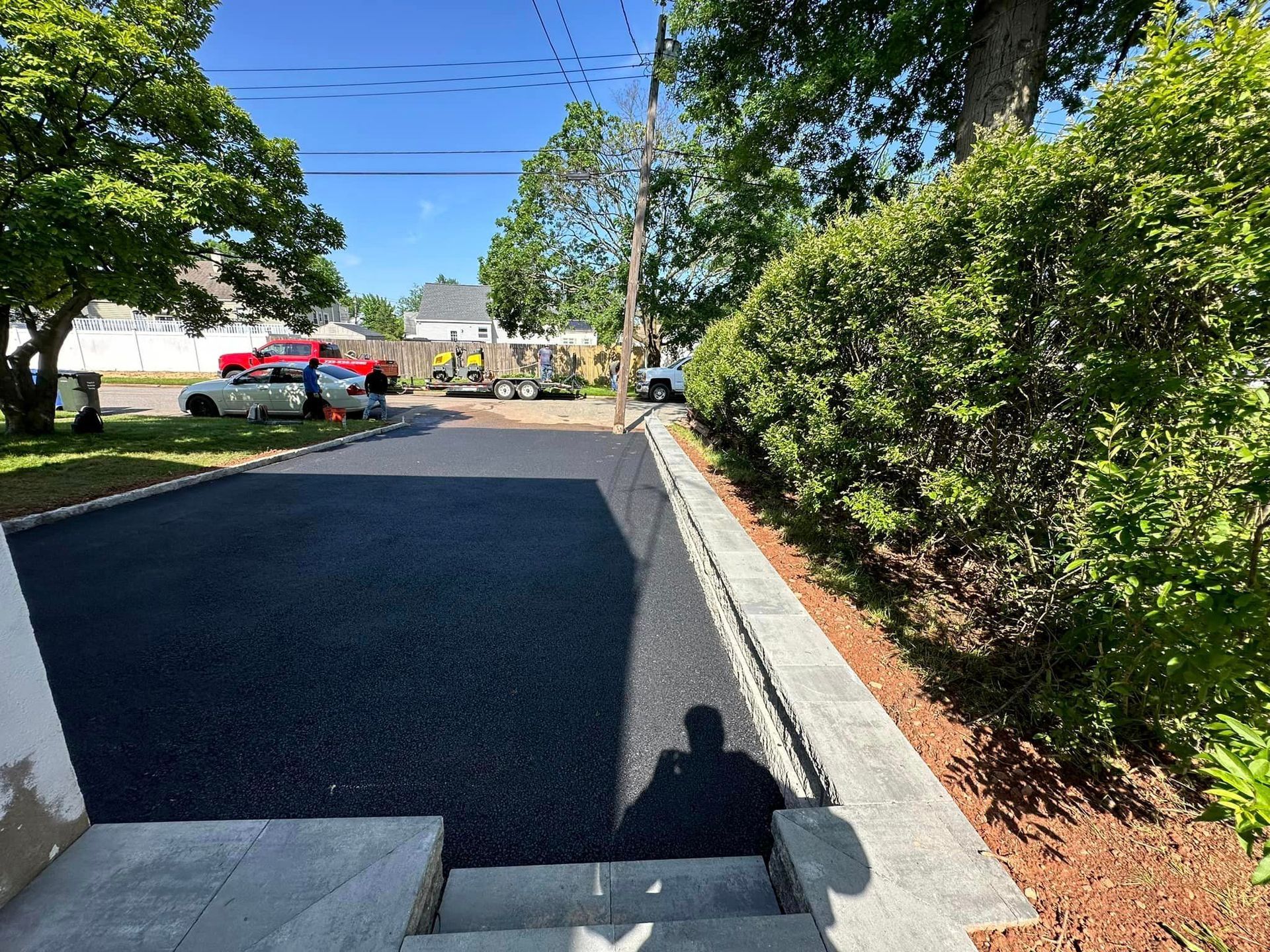 A shadow of a person is cast on the side of a road