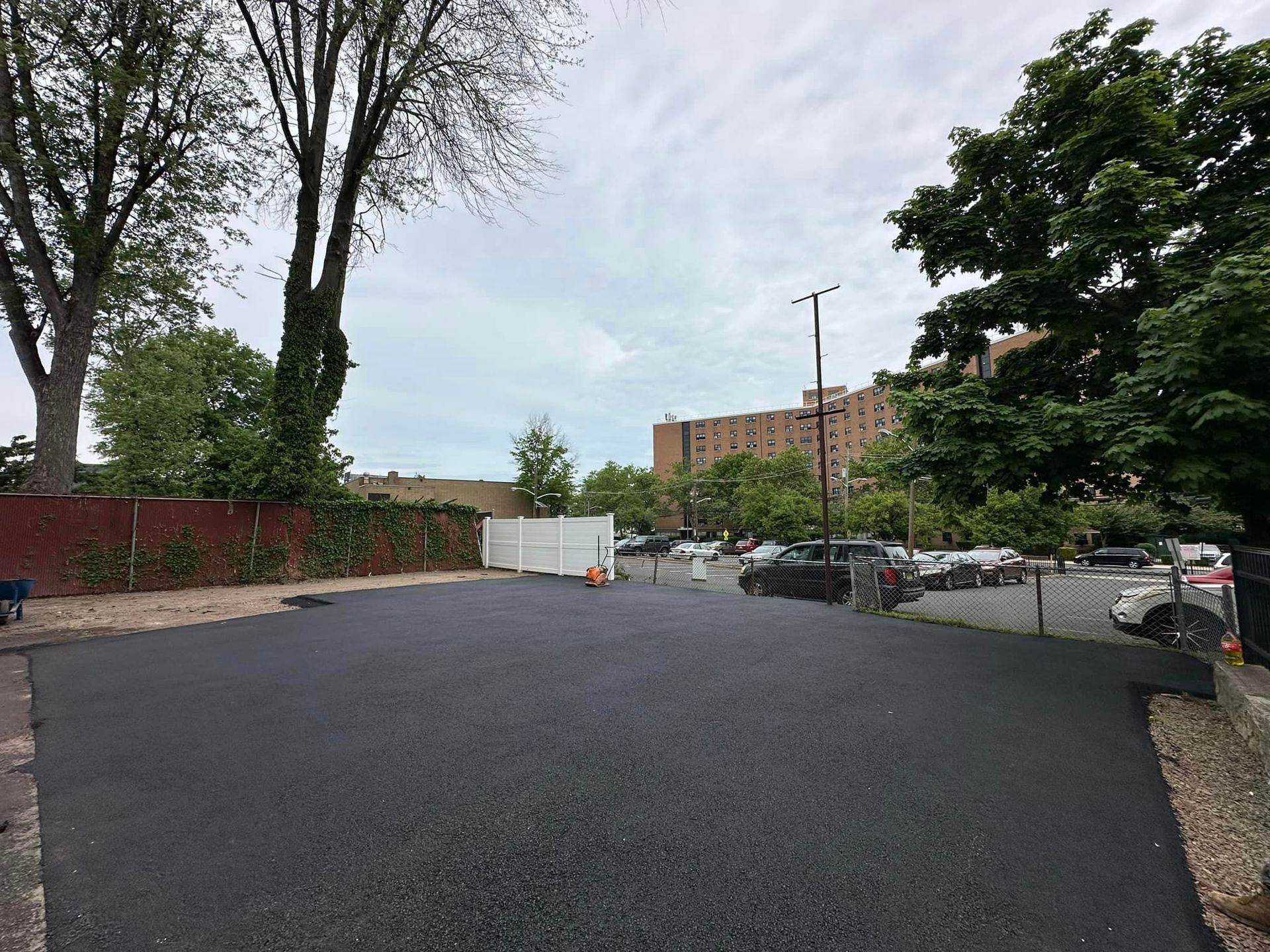 A parking lot with a lot of cars parked in it and a building in the background.