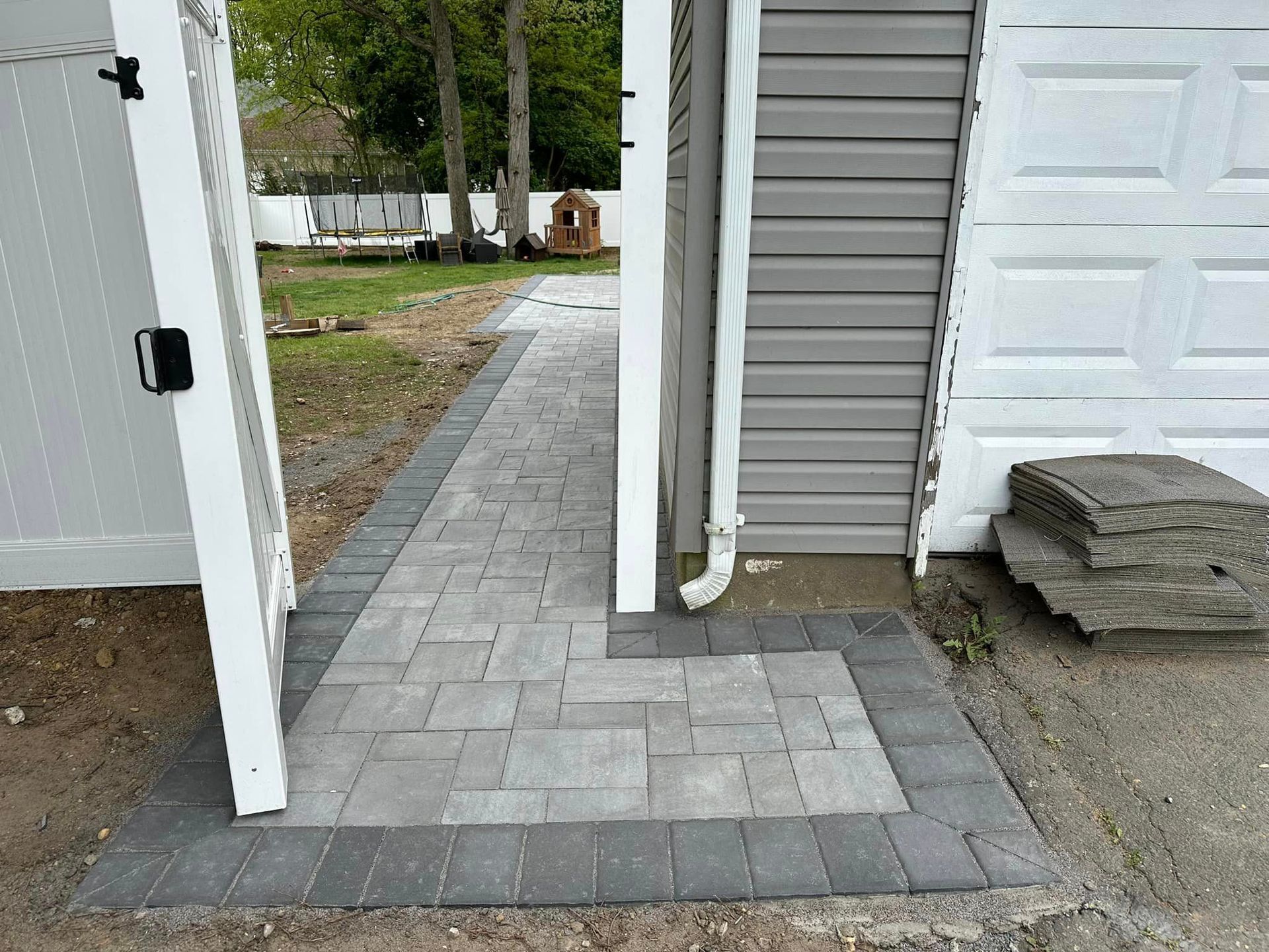 A brick walkway is leading to a garage door.