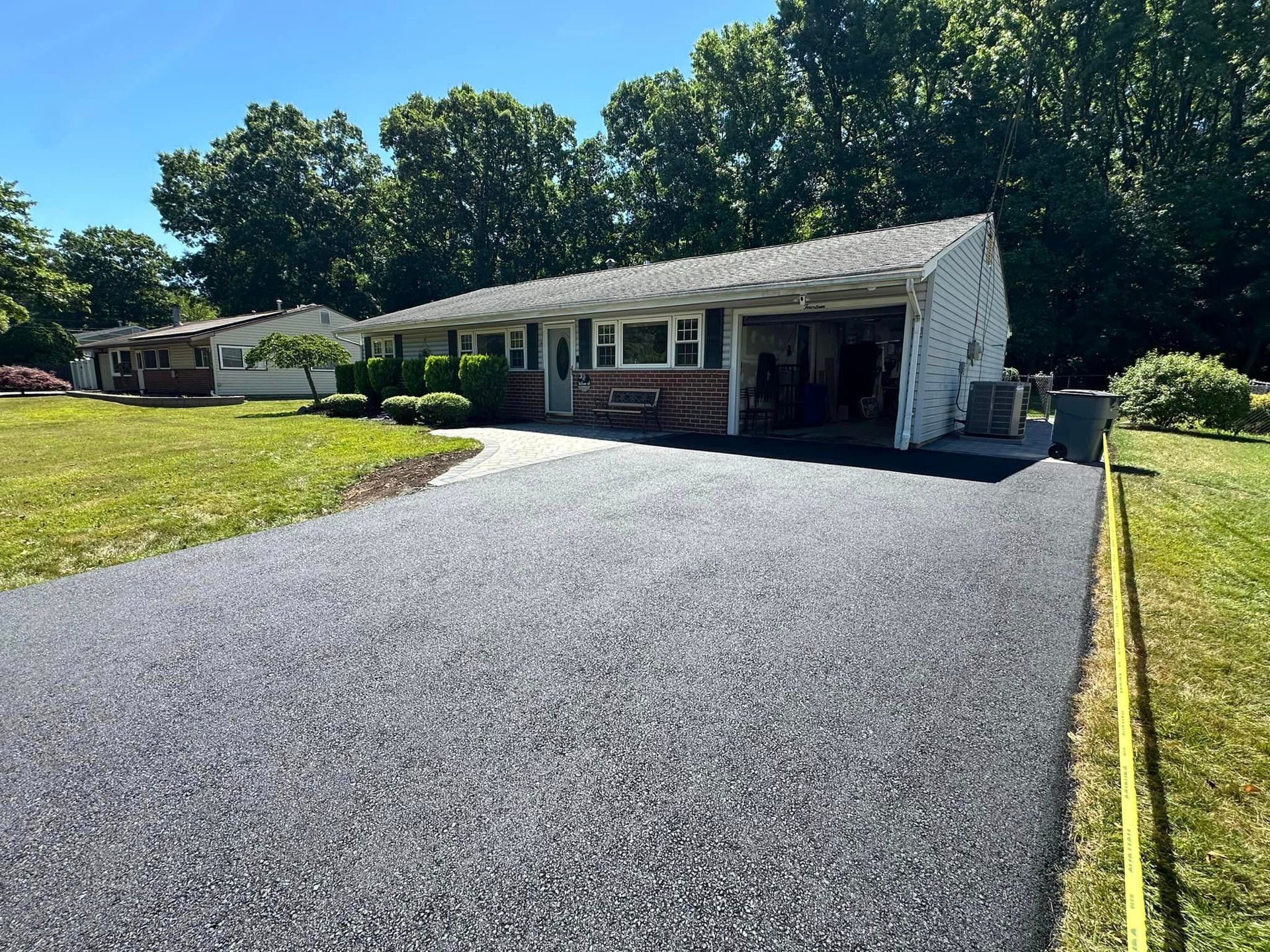 A house with a garage and a driveway in front of it.
