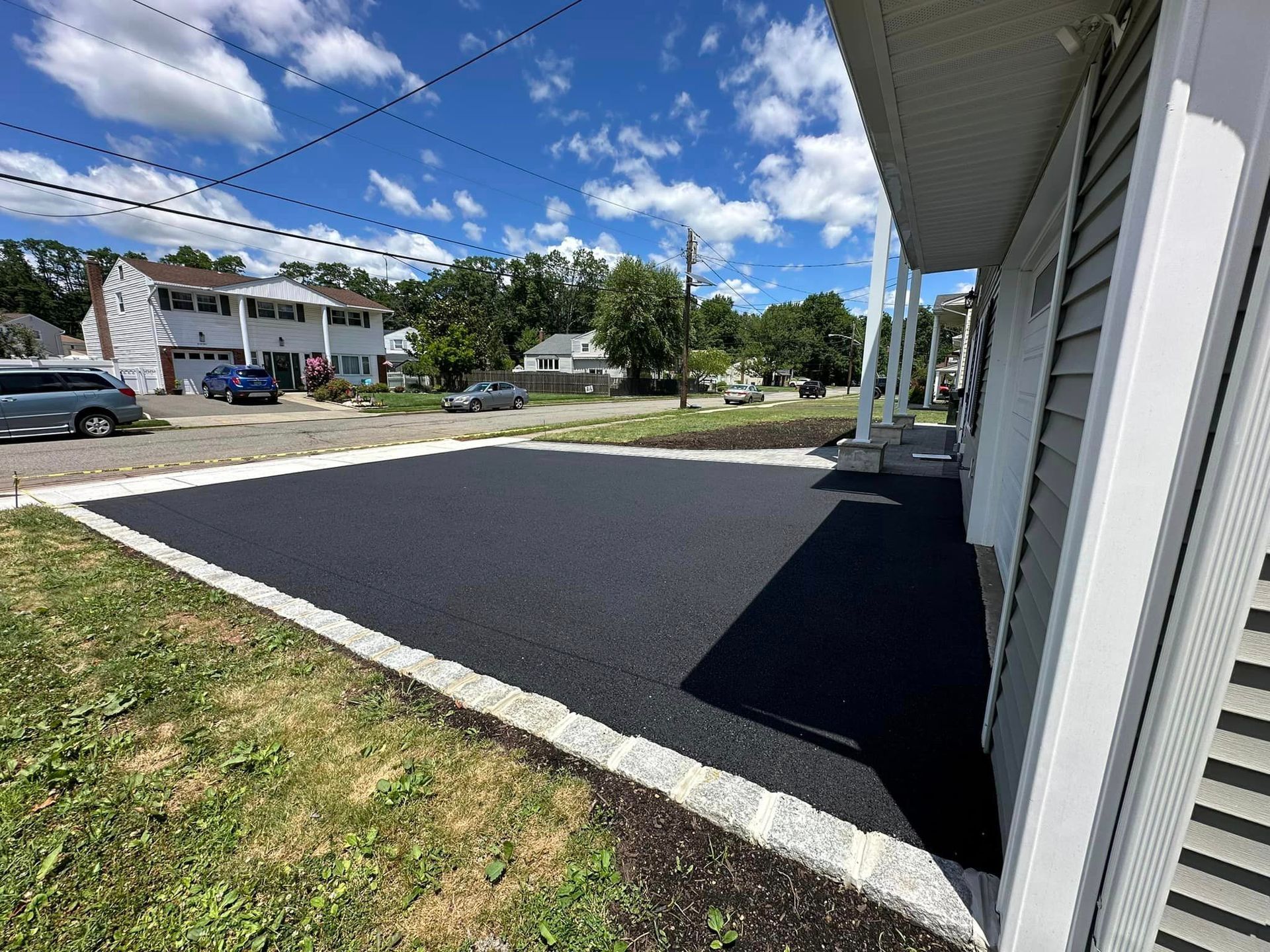 A house with a black driveway in front of it.