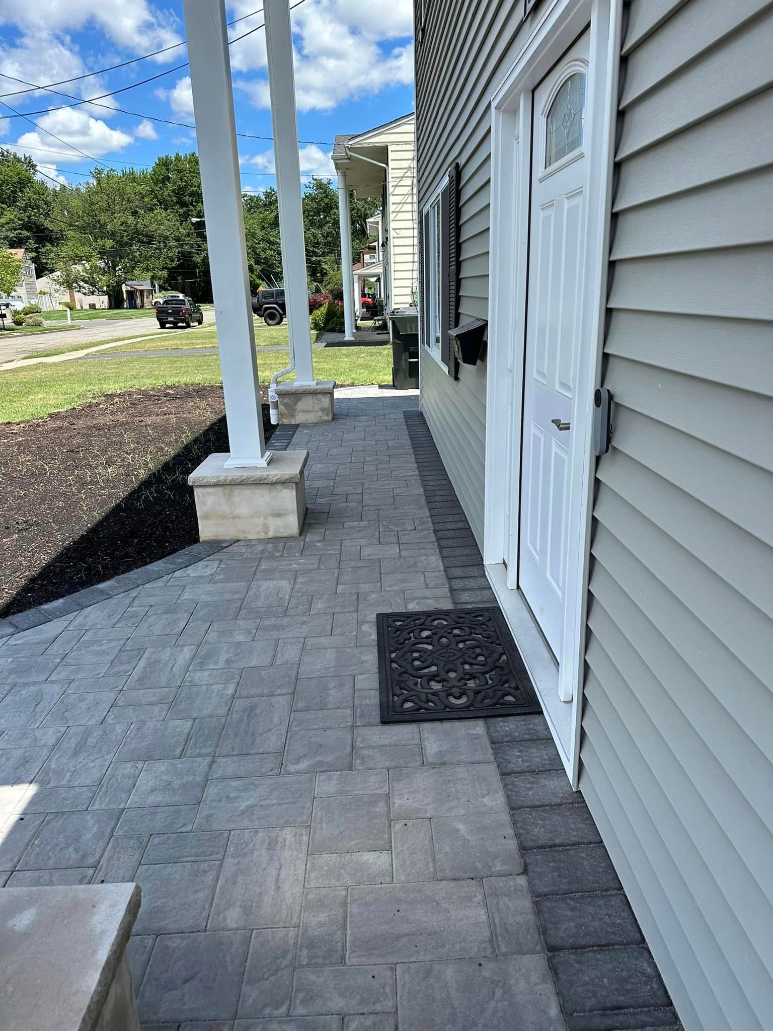 A brick walkway leading to the front door of a house.