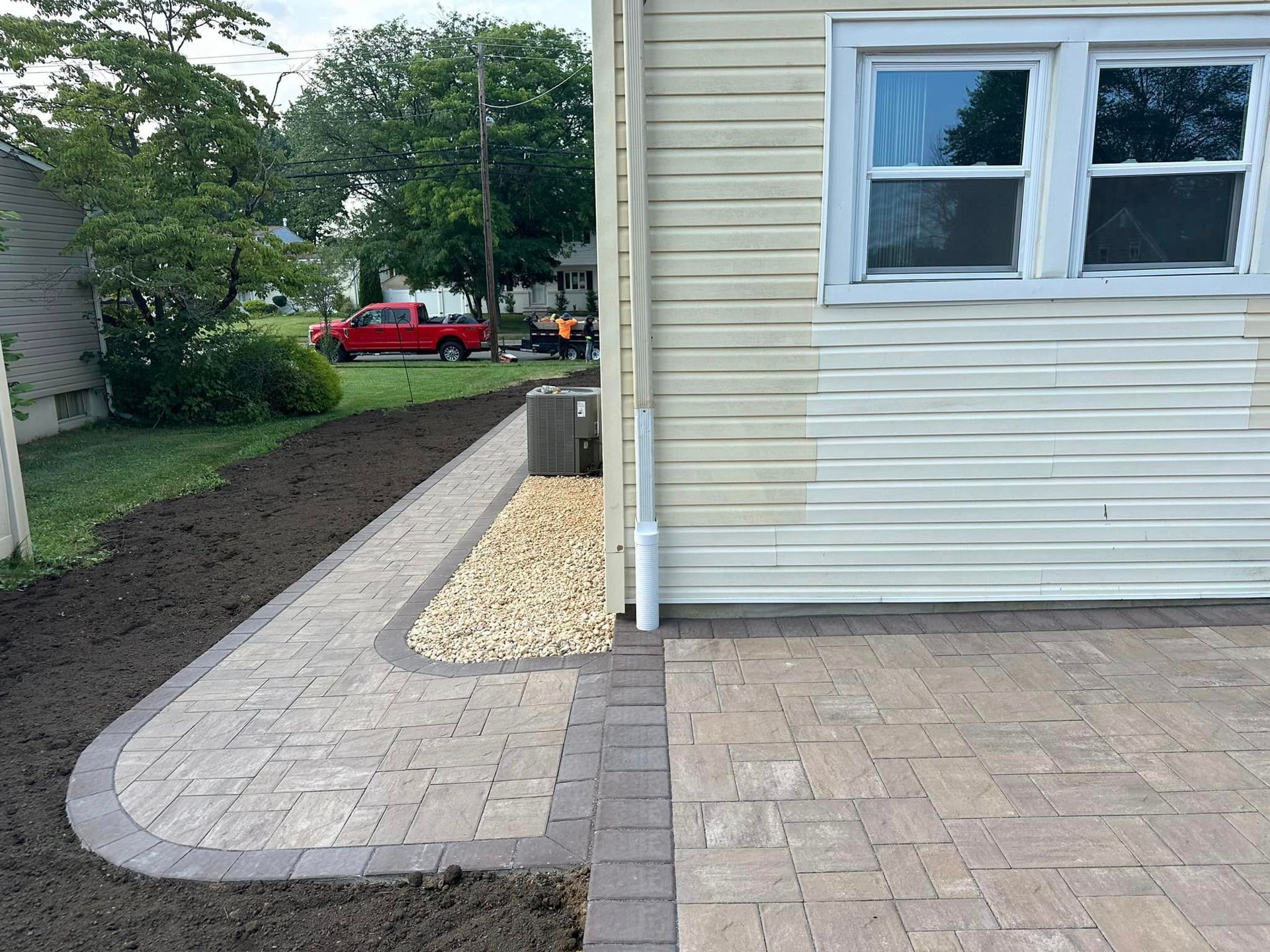 A white house with a red truck parked in front of it