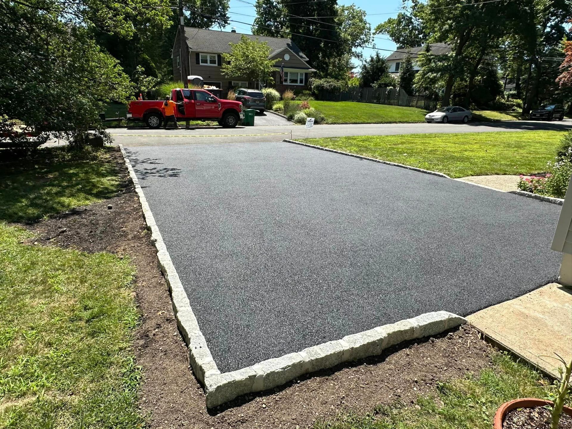 A red truck is parked in the driveway of a house.