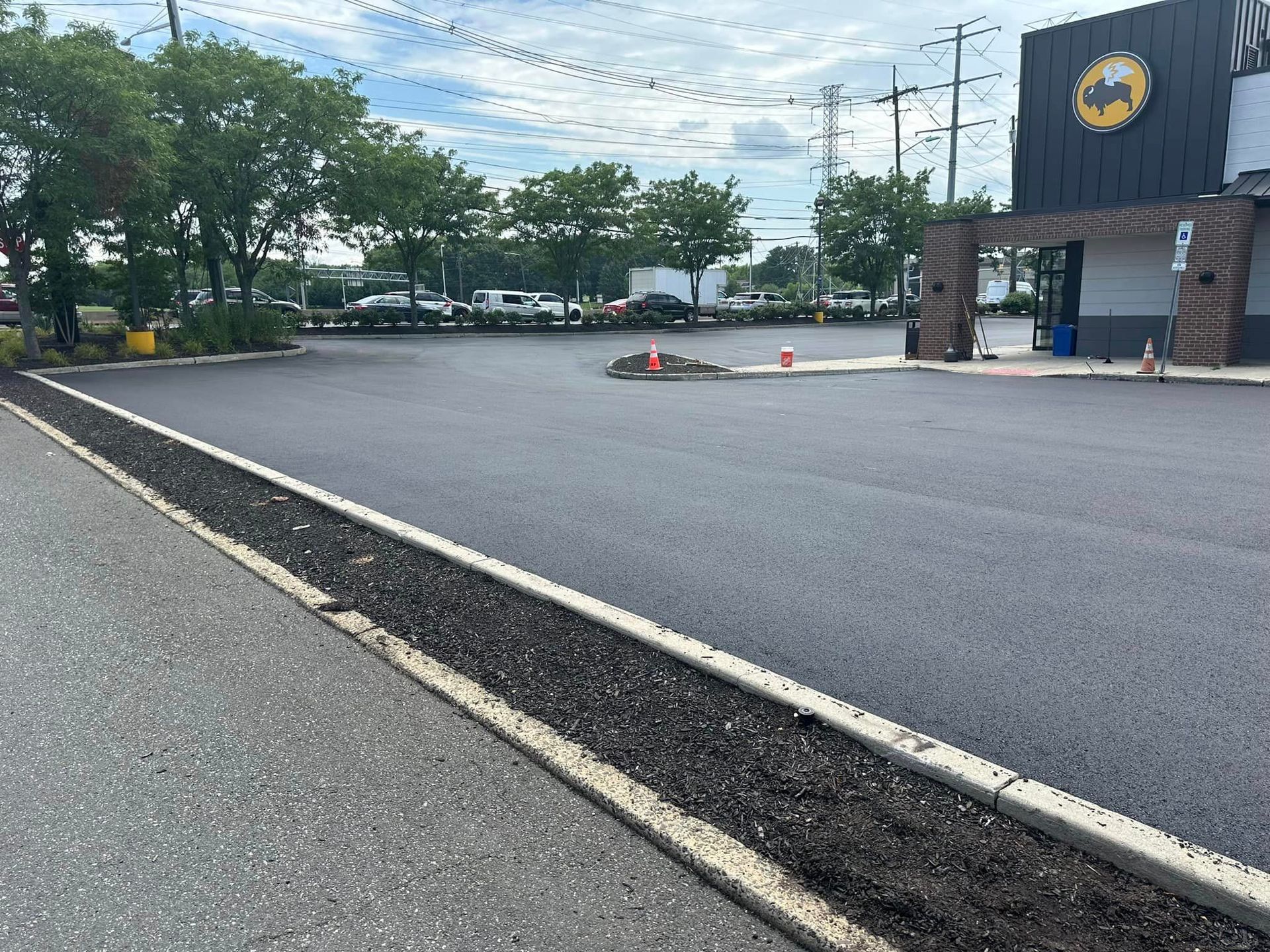 A parking lot in front of a building with a batman logo on it.