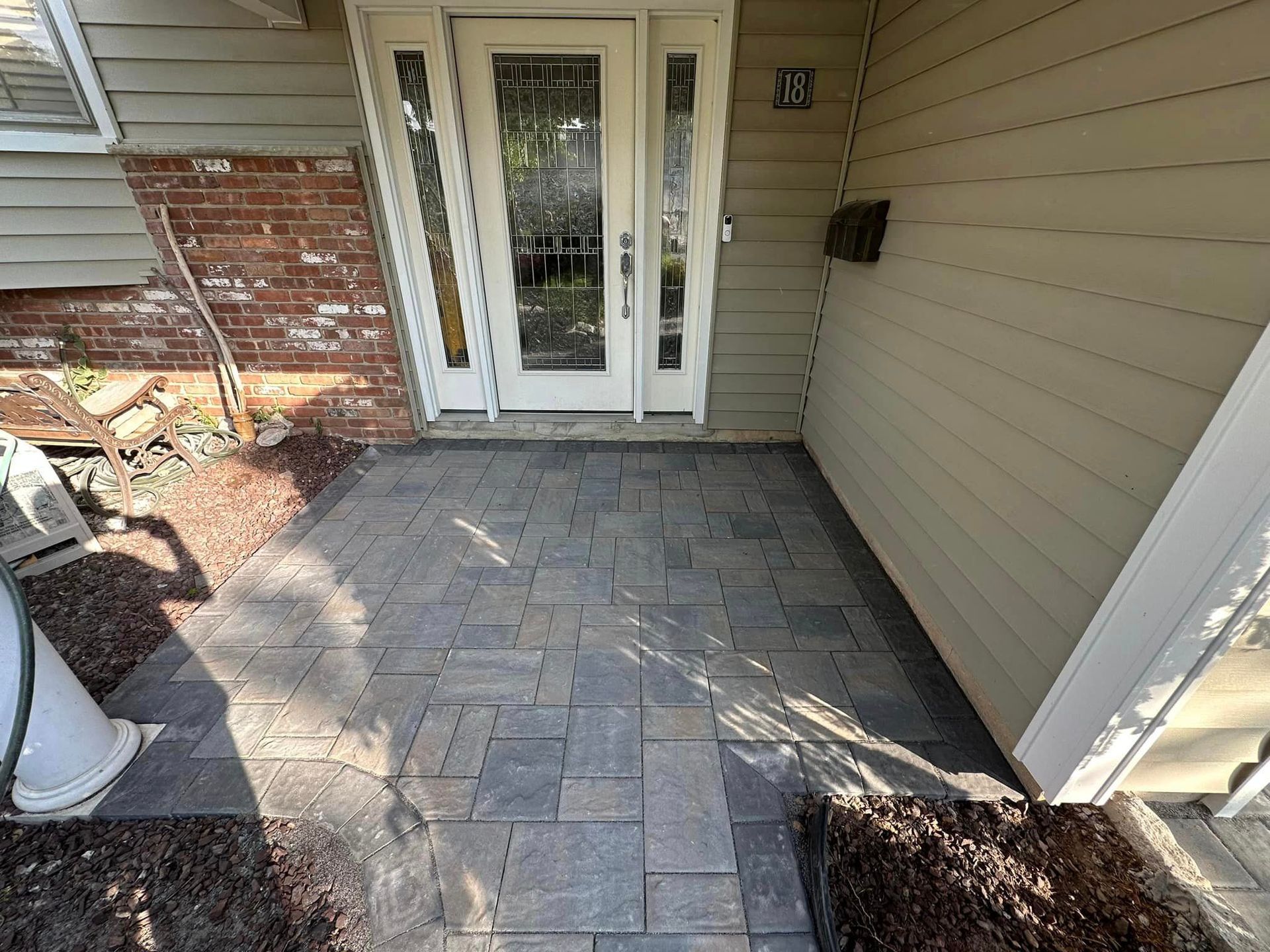 A brick walkway leading to the front door of a house.