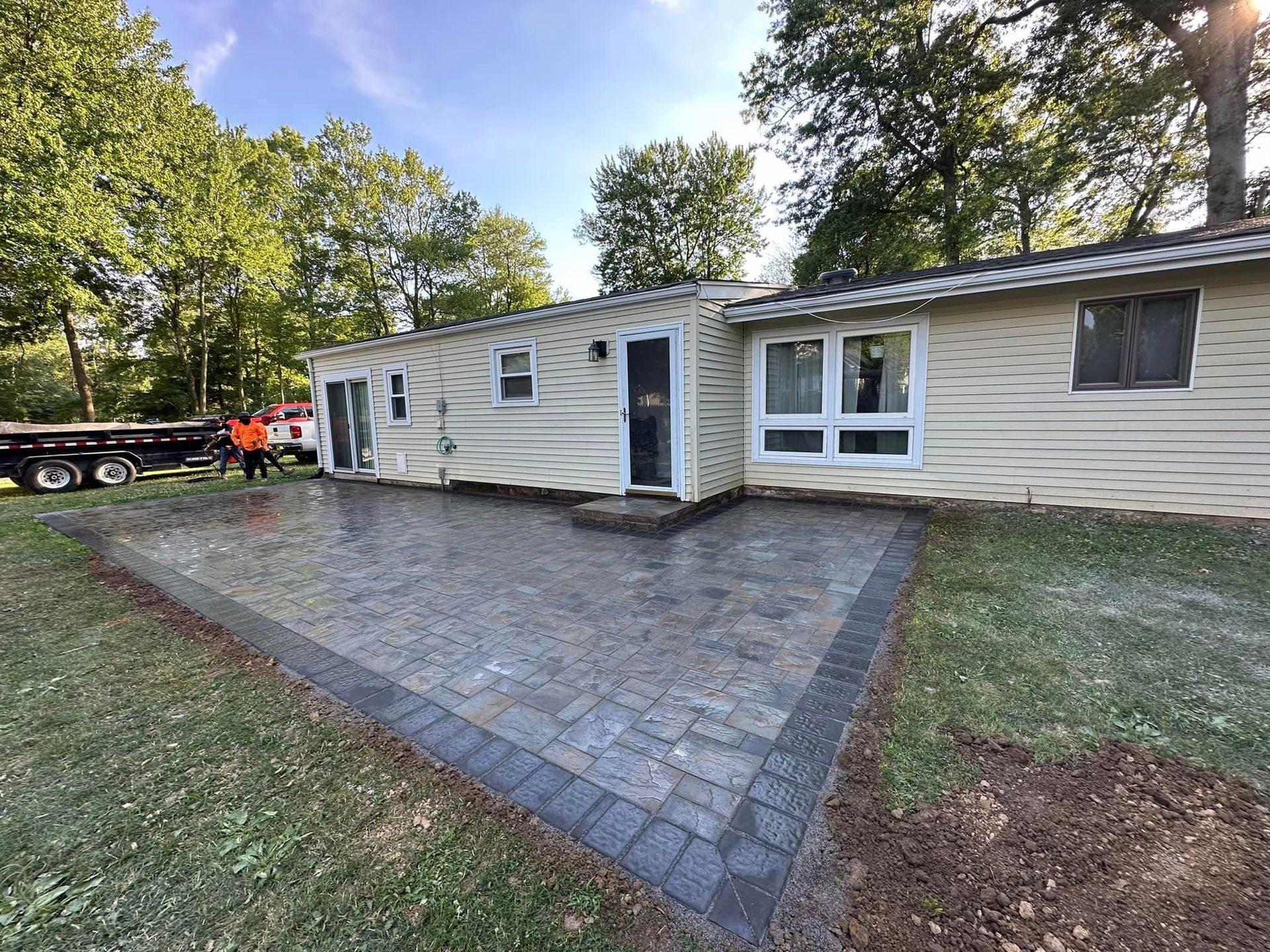 A house with a patio and a truck parked in front of it.