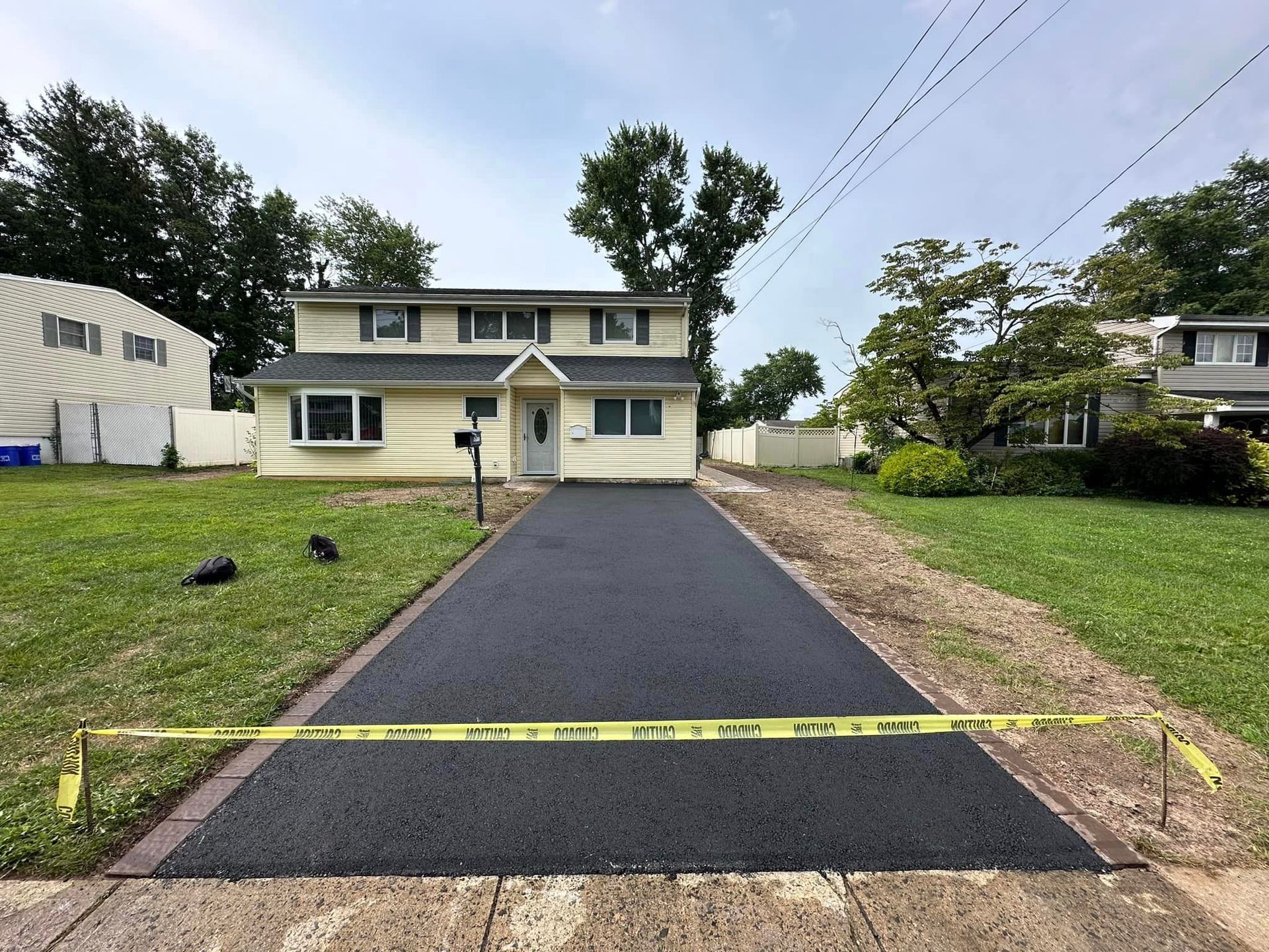 A house with a driveway that is being paved in front of it