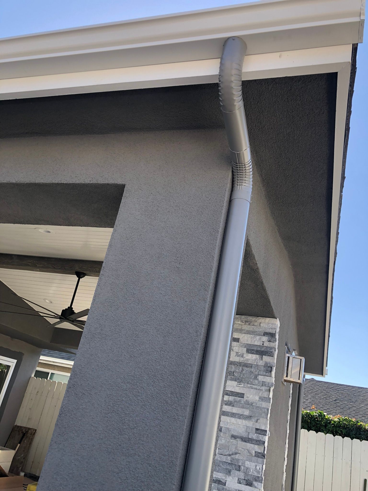 A close up of a gutter on the side of a building