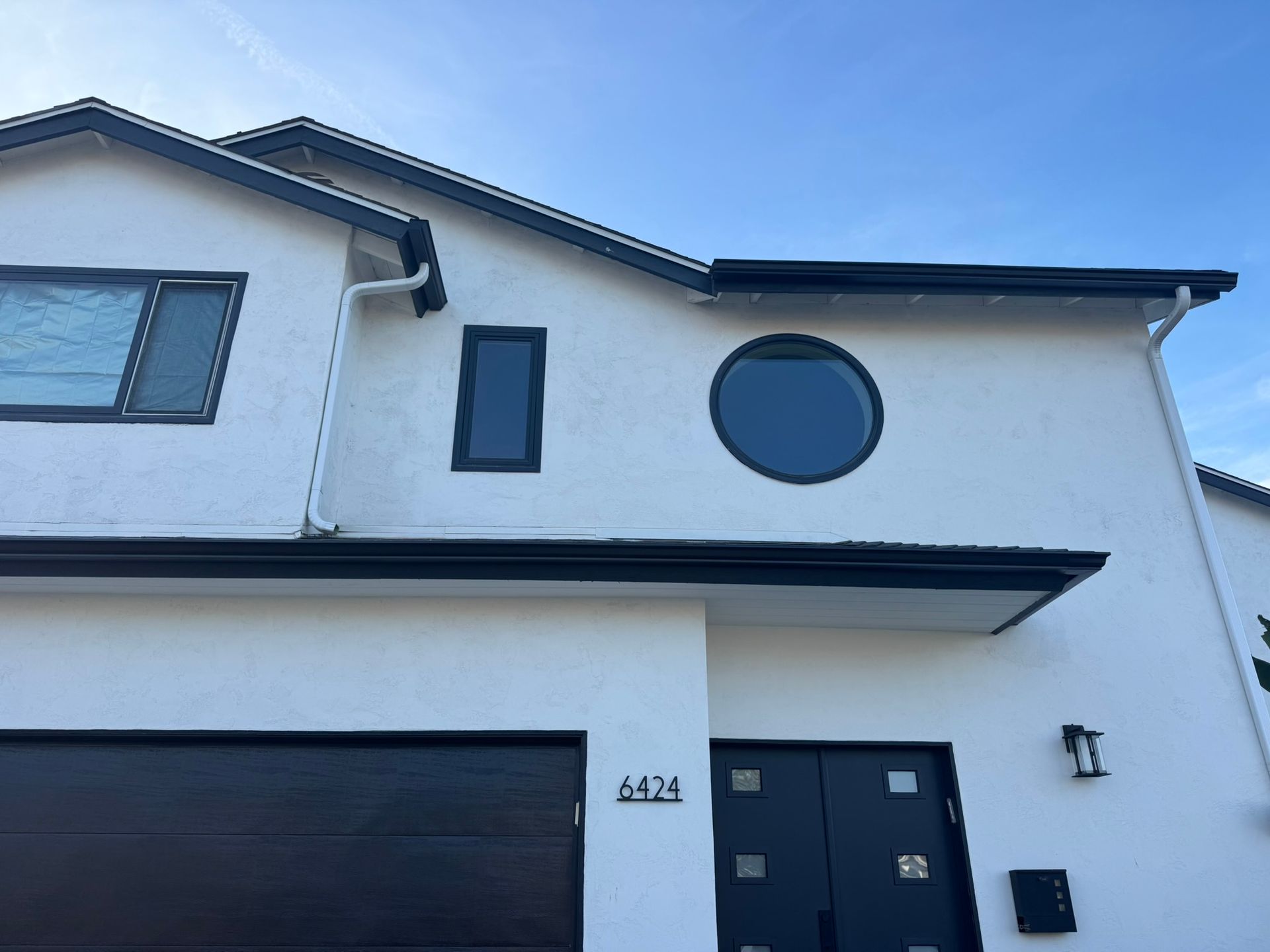 A white house with black trim and a black garage door