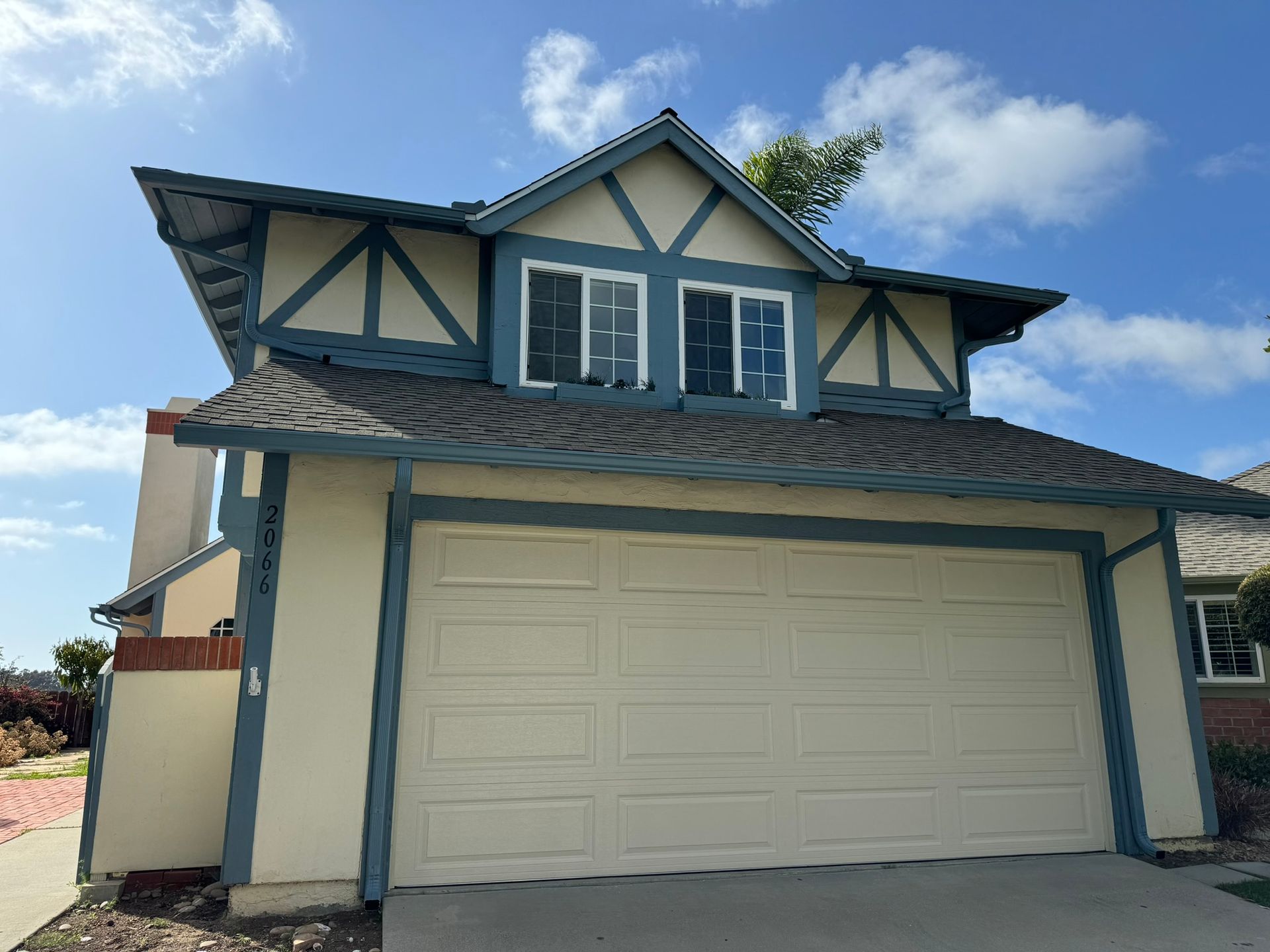 A house with a blue roof and a white garage door