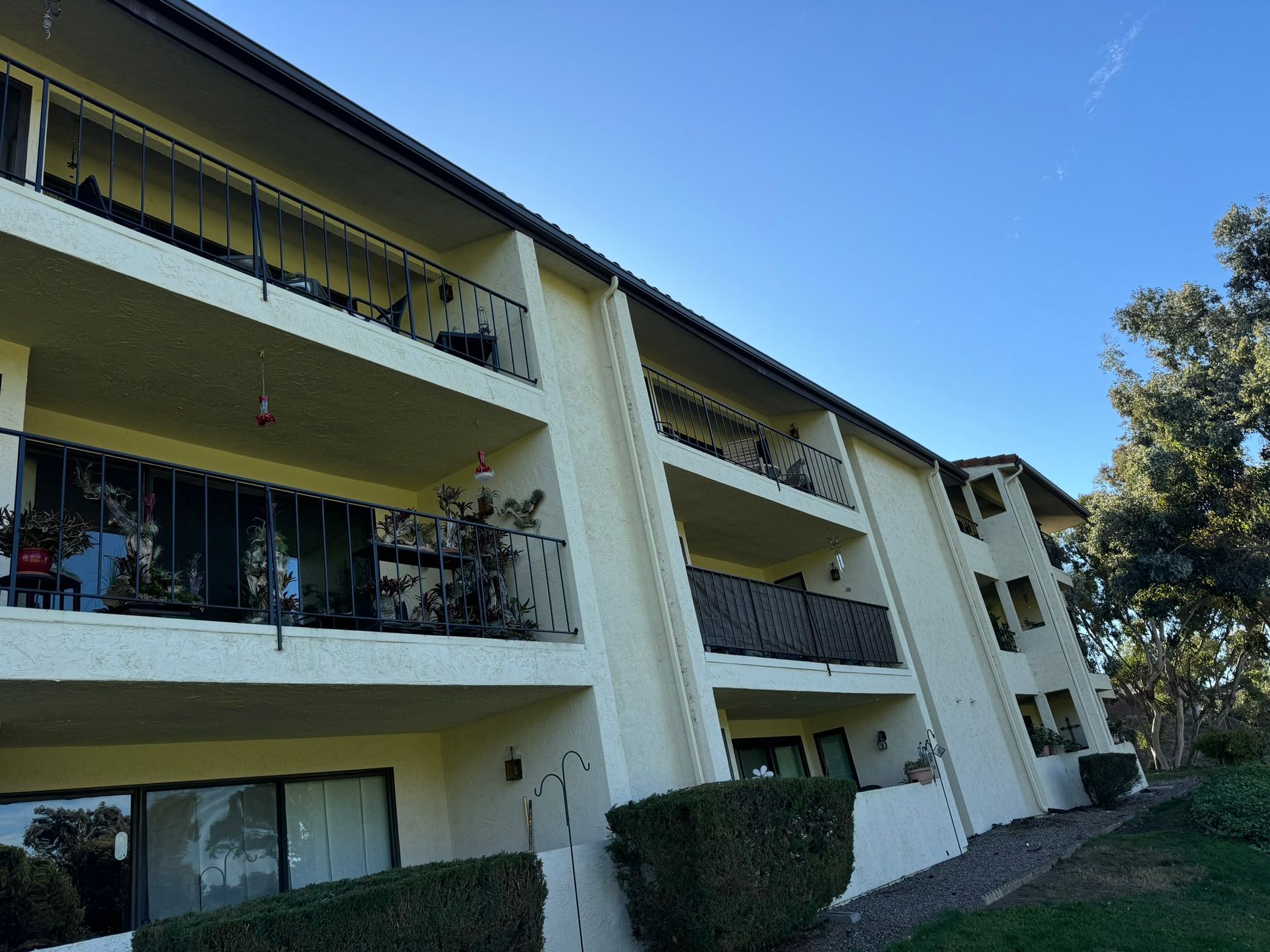 A white apartment building with balconies and a blue sky in the background