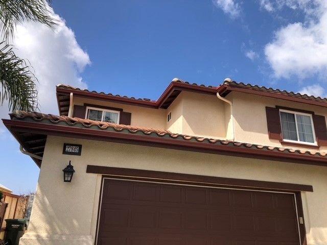 A house with a brown garage door and a blue sky in the background