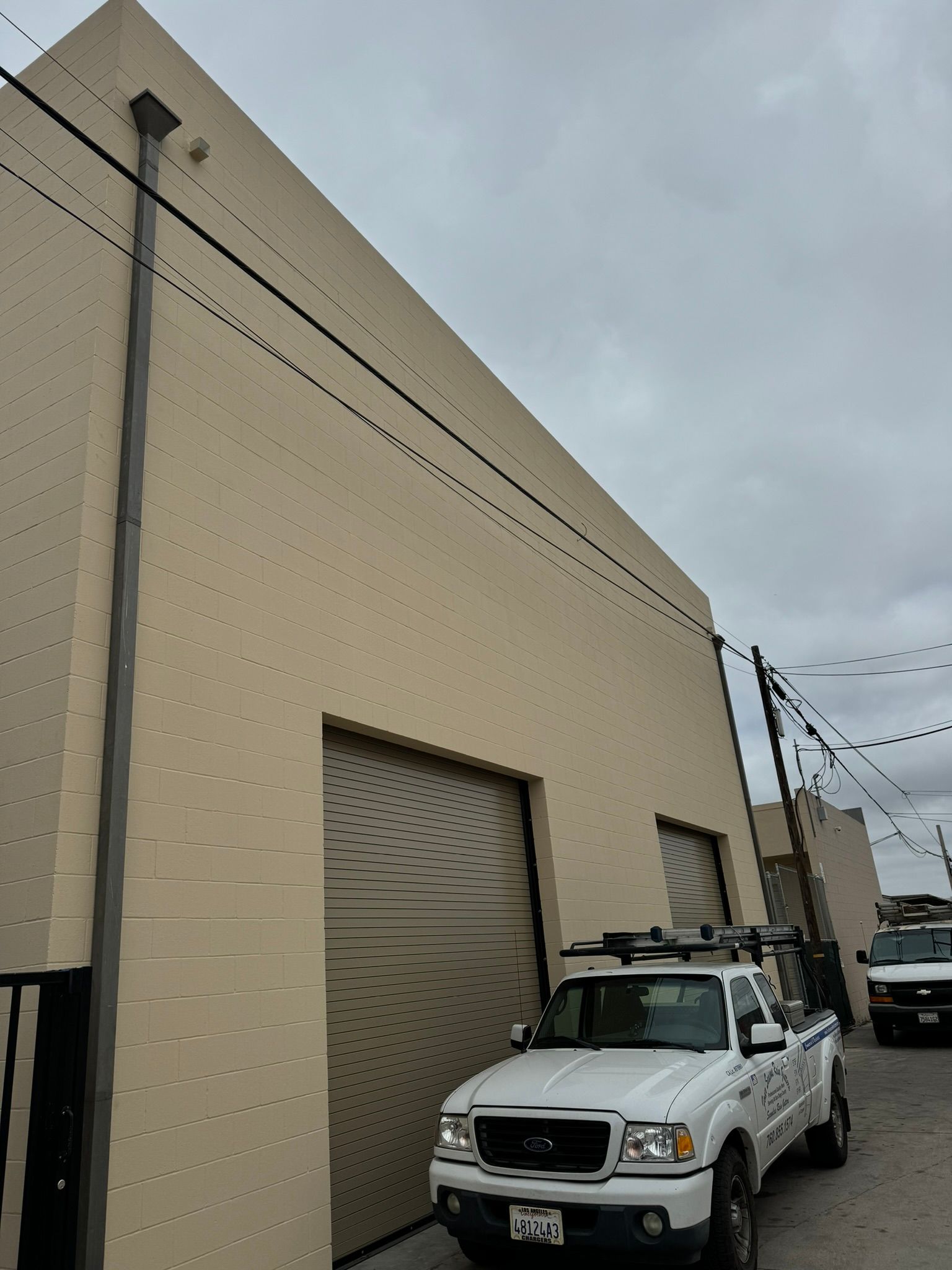 A white truck is parked in front of a building