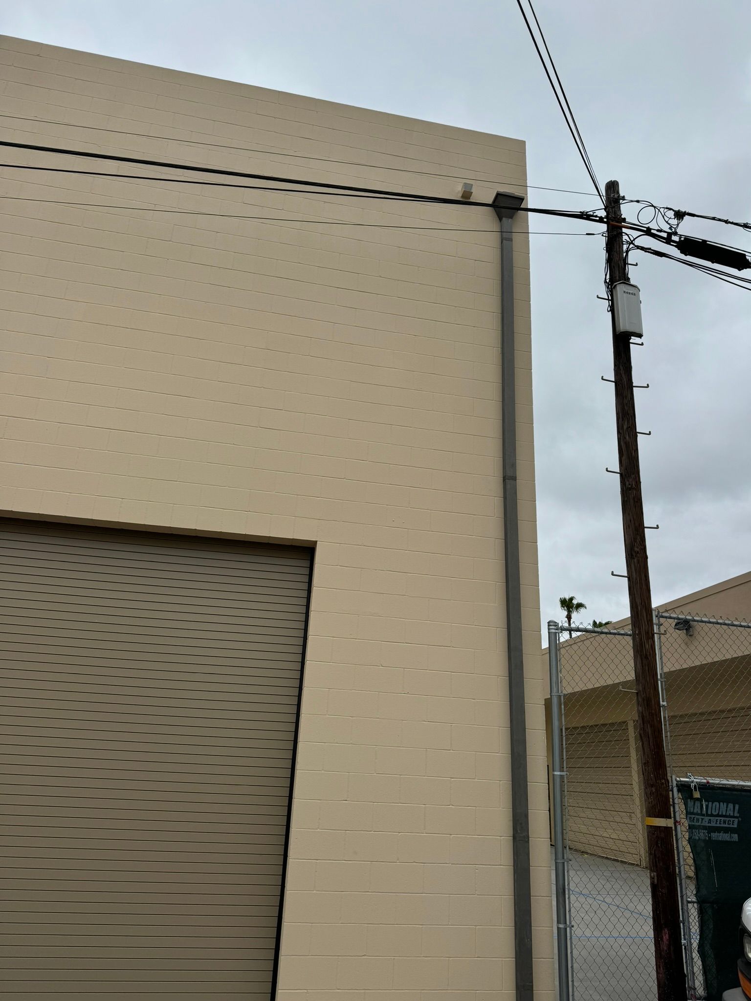 A building with a garage door and a telephone pole