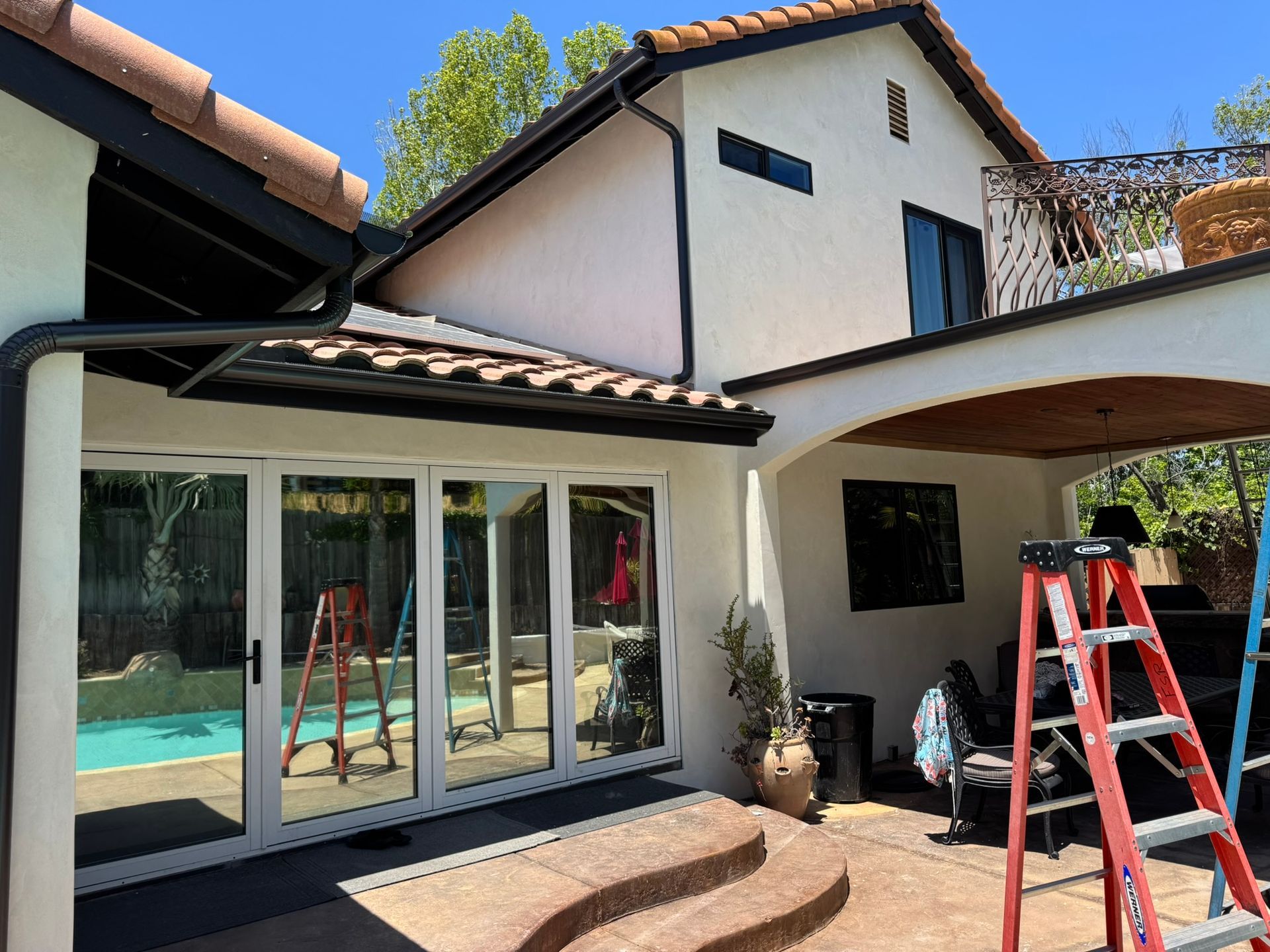 A house with a pool and a ladder in front of it.