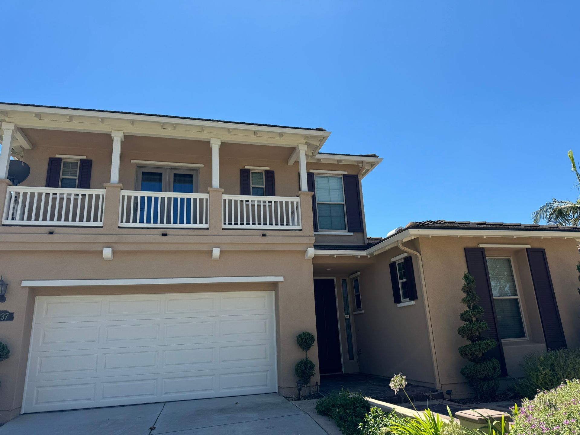 A house with a white garage door and a balcony