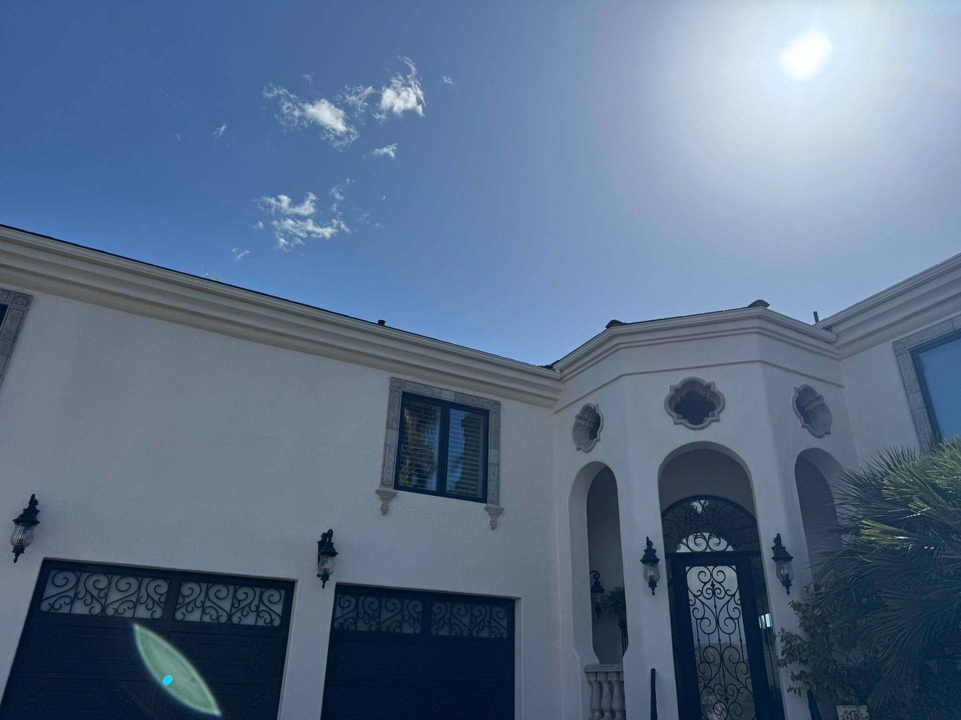 A large white house with a blue sky in the background