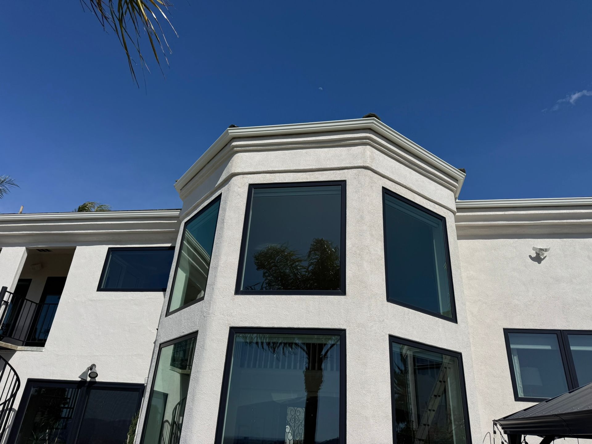 A white house with a lot of windows and a blue sky in the background
